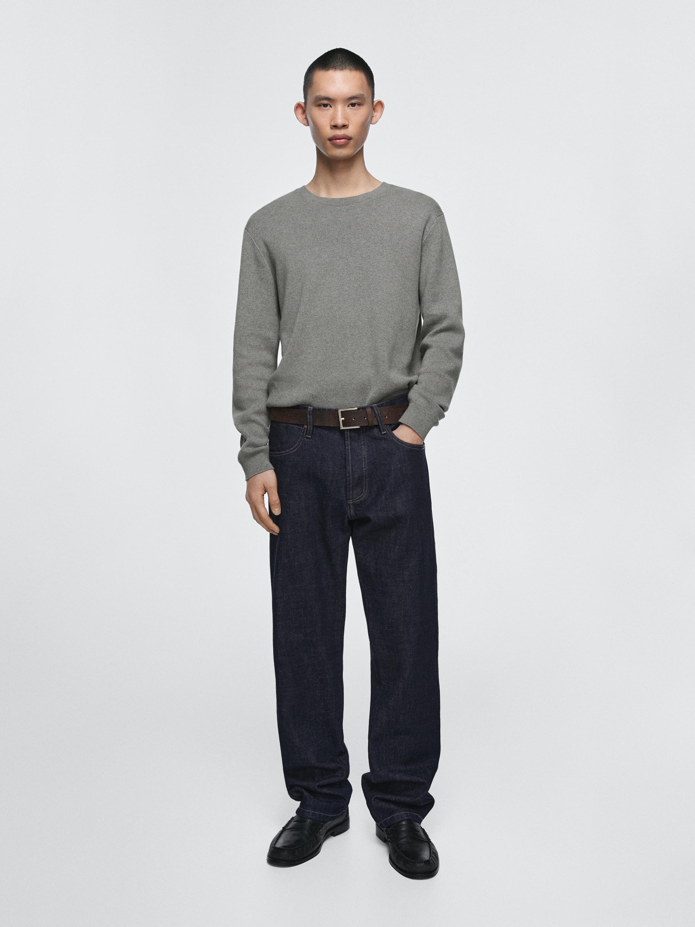 Graues Langarm-Pullover-Set und dunkelblaue Jeans im Relaxed Fit mit Seitentaschen.