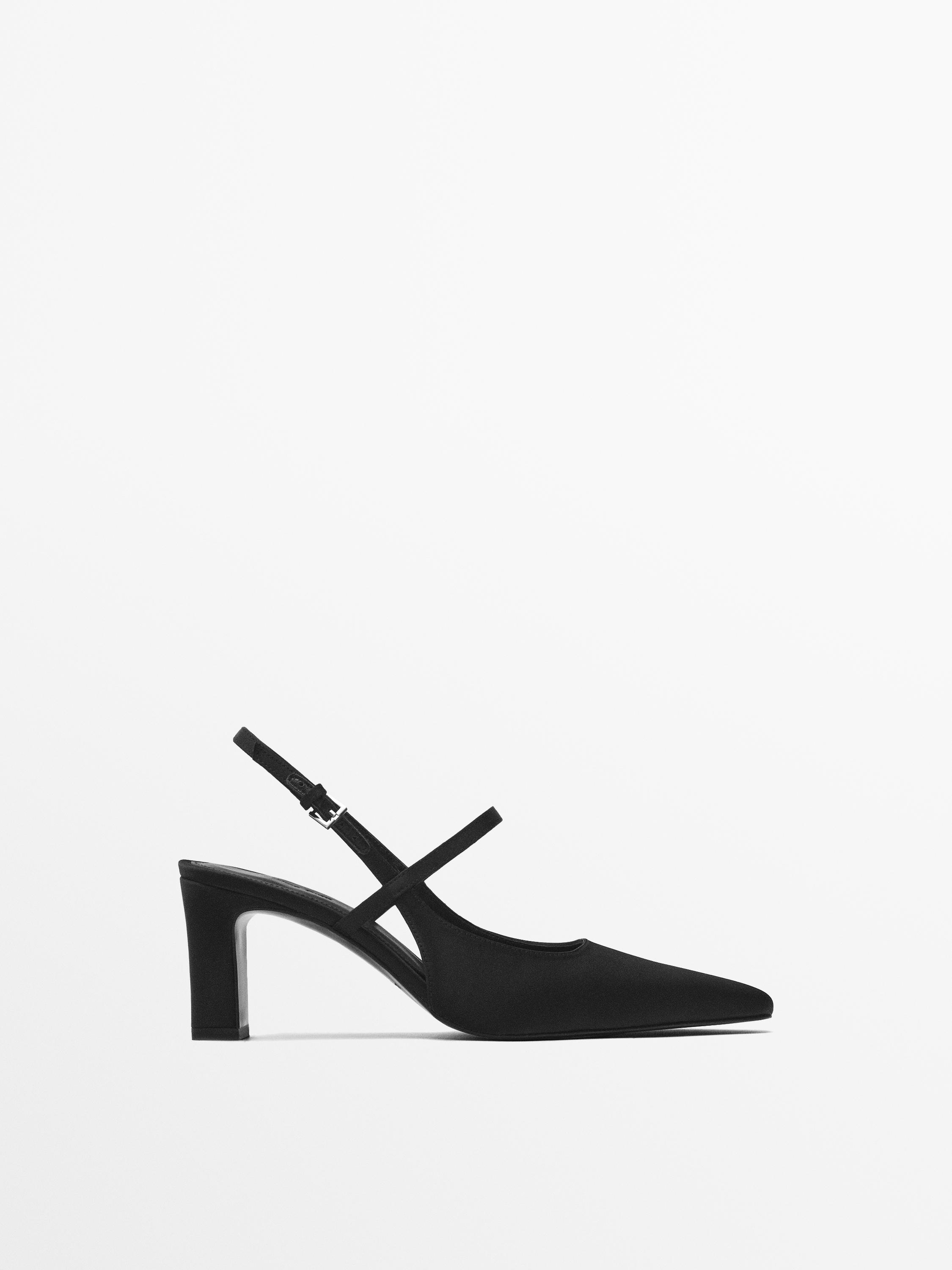 Vue latérale d'une chaussure noire à talon moyen avec une bride ajustable.