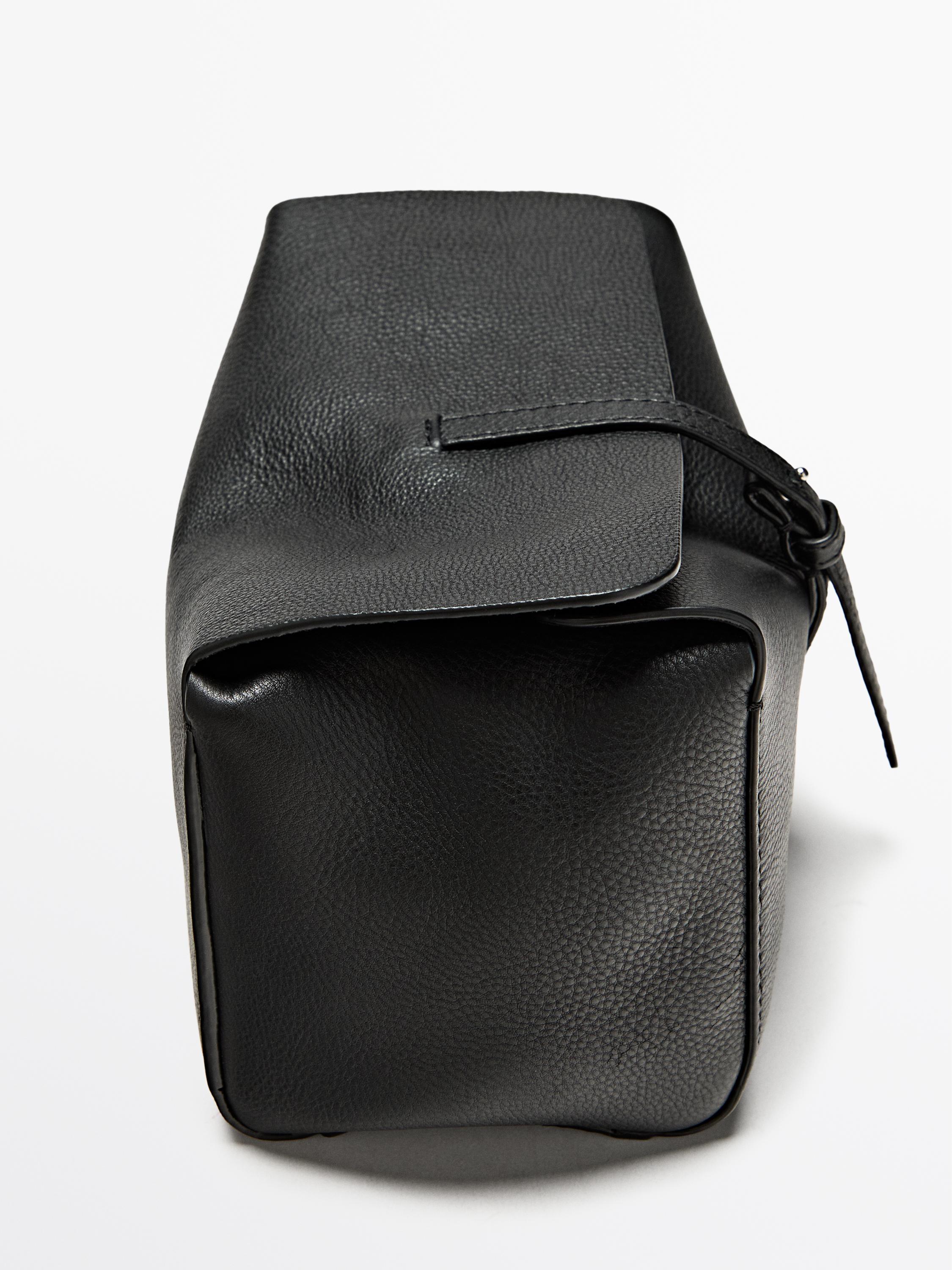 Детали черной косметички с клапаном и боковой завязкой.