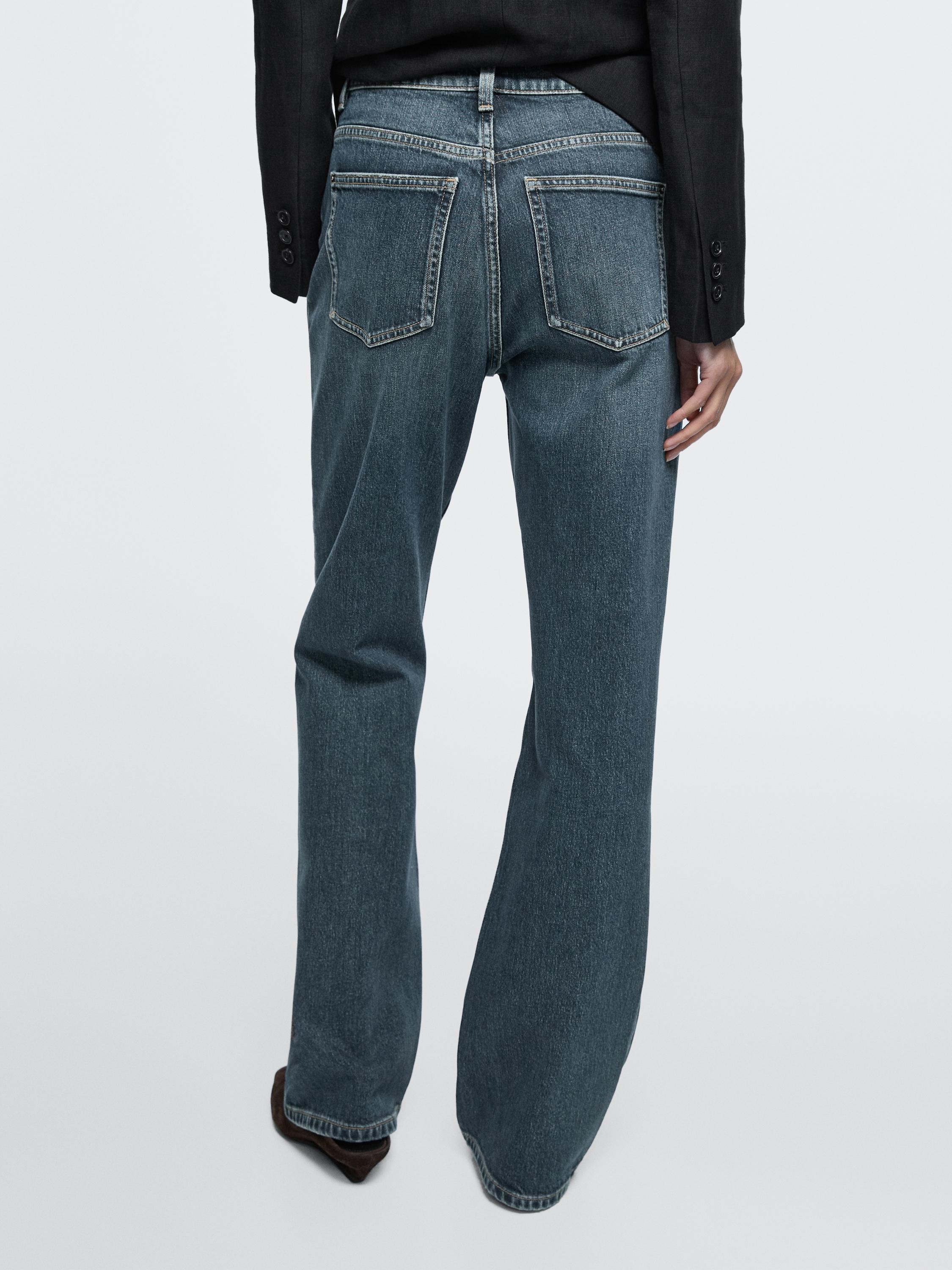 Erdiko neurriko bootcut fit tiro altuko jeans multzoa, atzeko poltsiko ikusgarriekin.