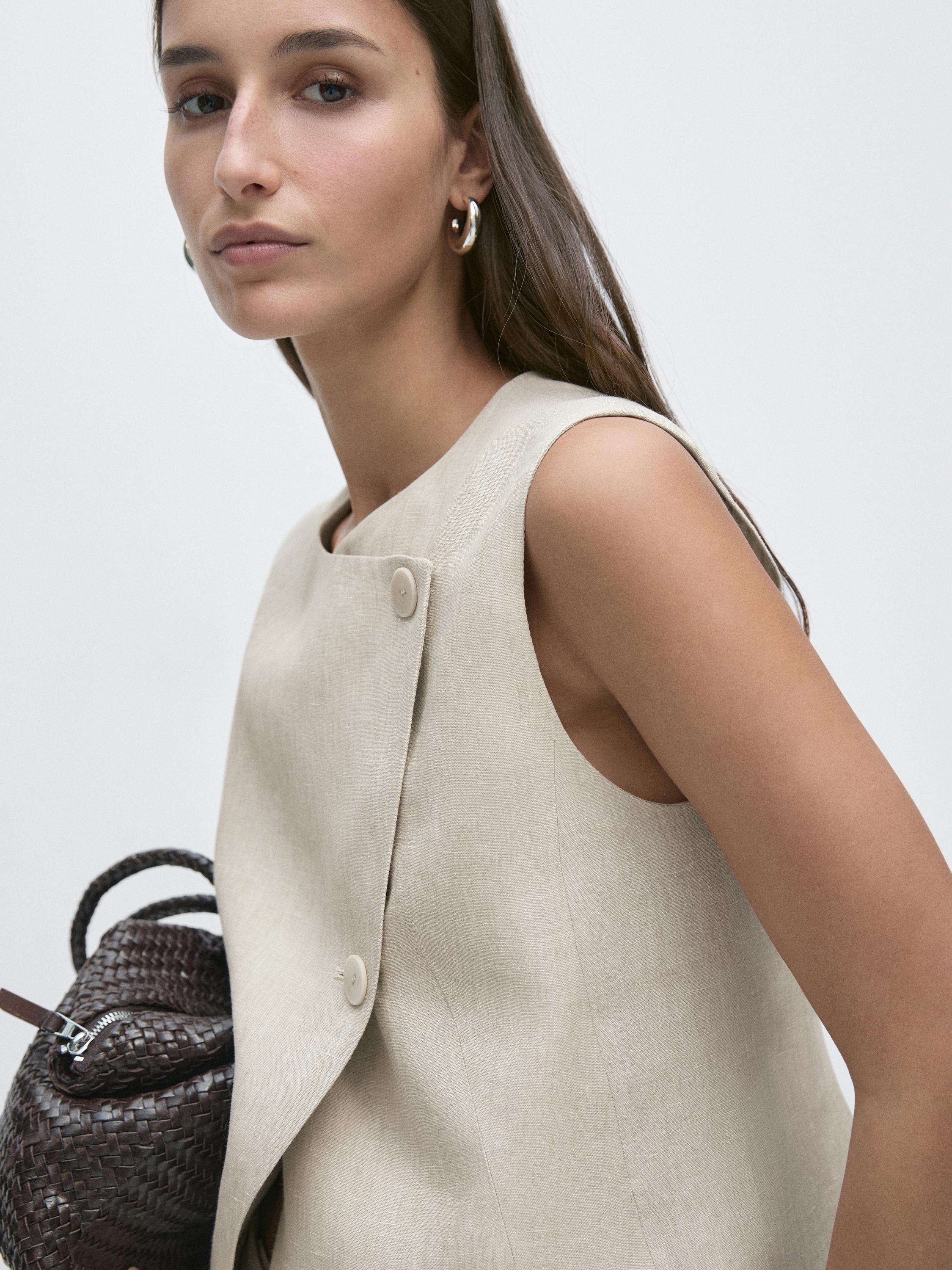 "Plano medio de chaleco piedra con botonadura lateral visible."