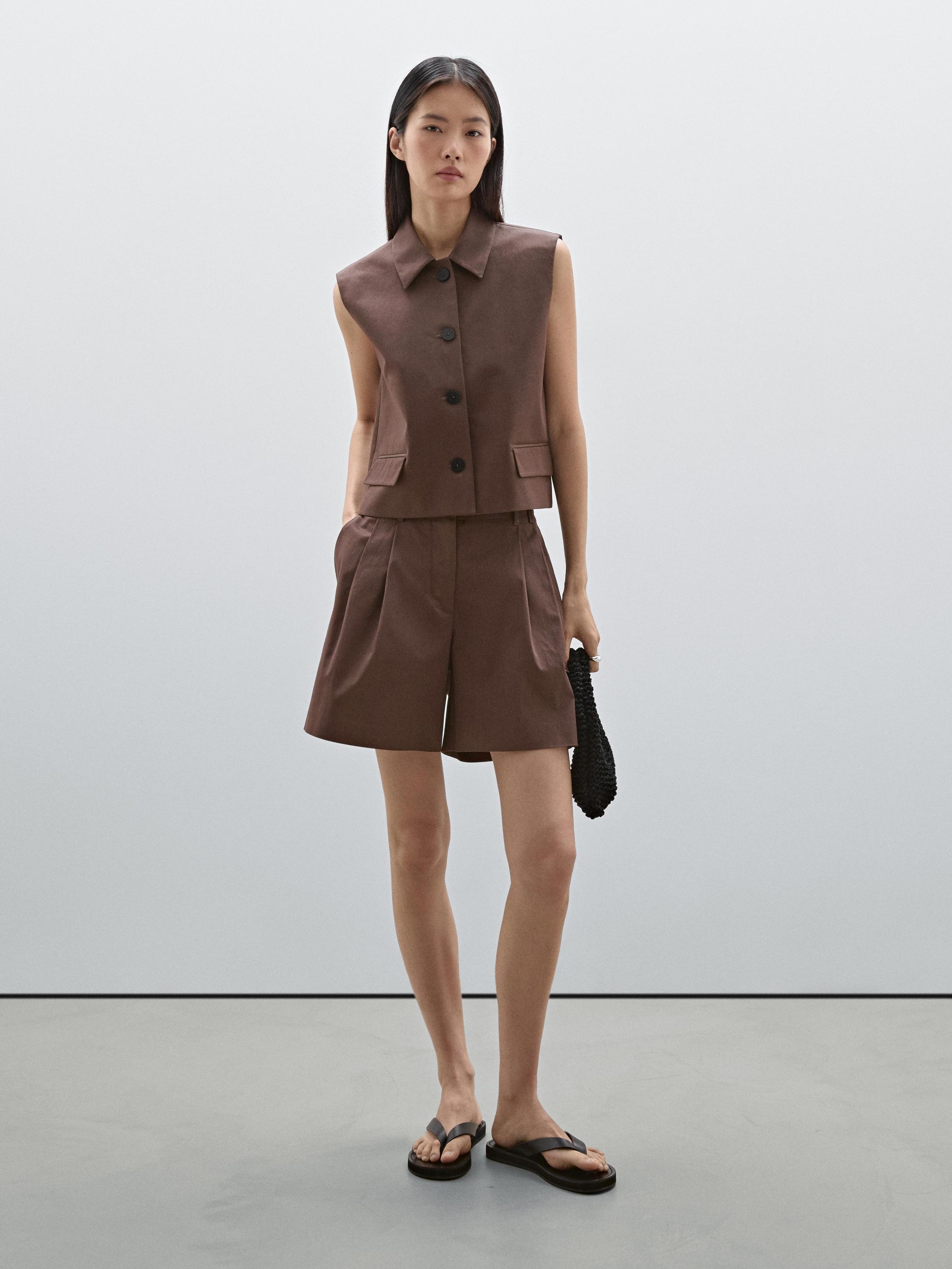 Brown sleeveless vest set with buttons and pockets, and brown shorts.