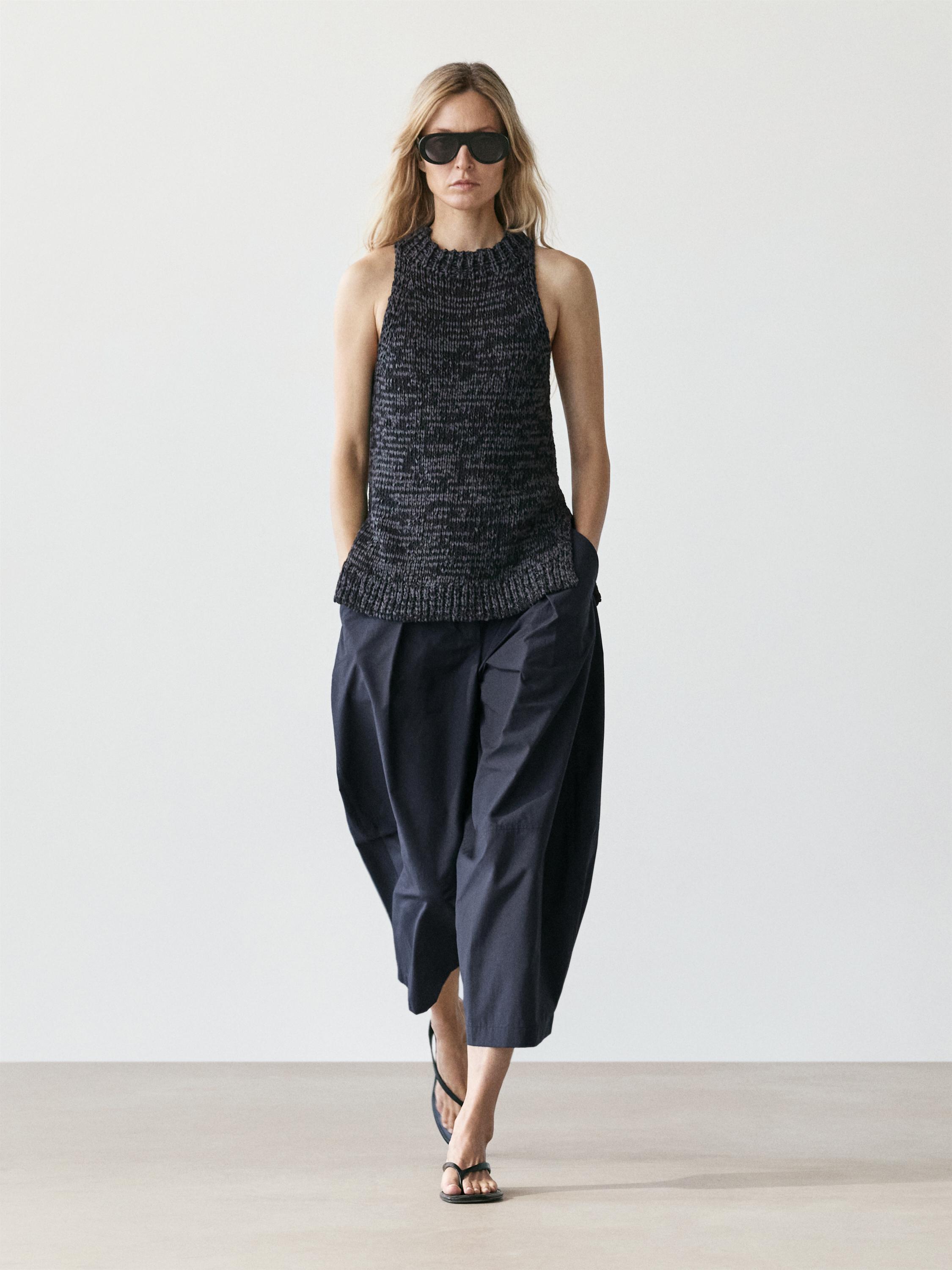 Conjunto de top halter jaspeado plomo y pantalones anchos oscuros.