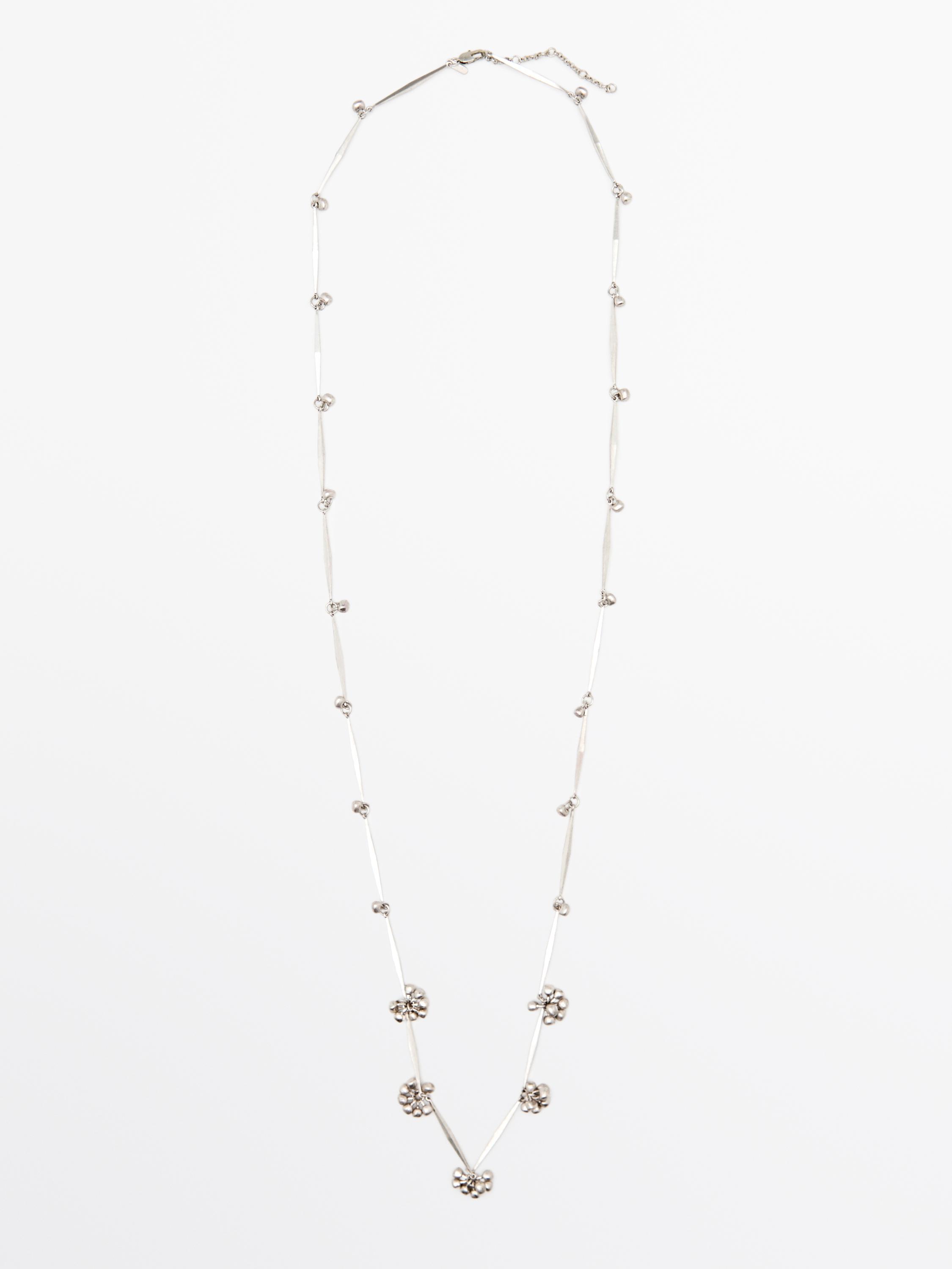 Silver metallic chain necklace with bead details and small flowers distributed throughout.