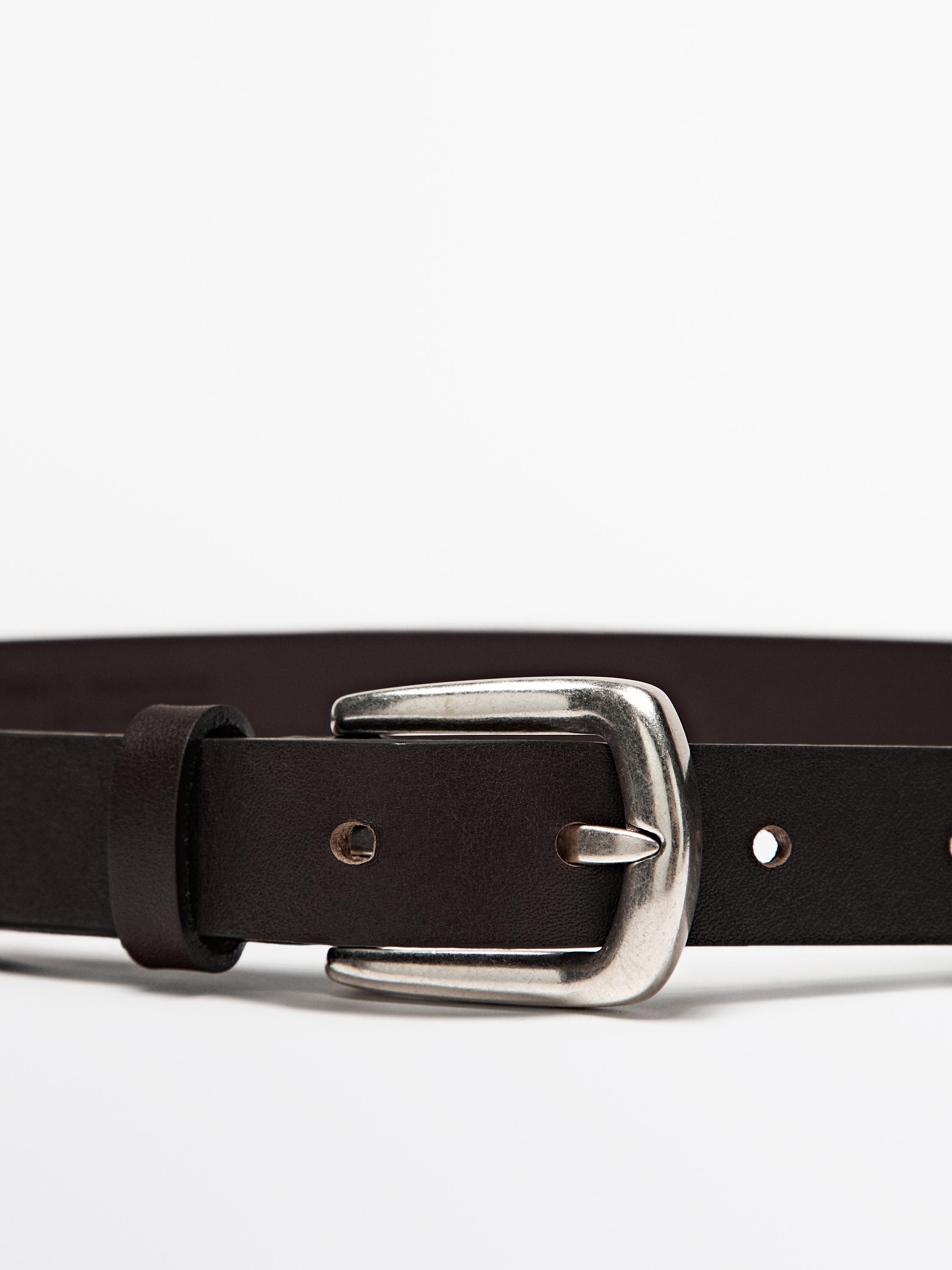 Belbog'dagi metall to'qali detal, sozlanuvchi teshiklari bor jigarrang rangda.