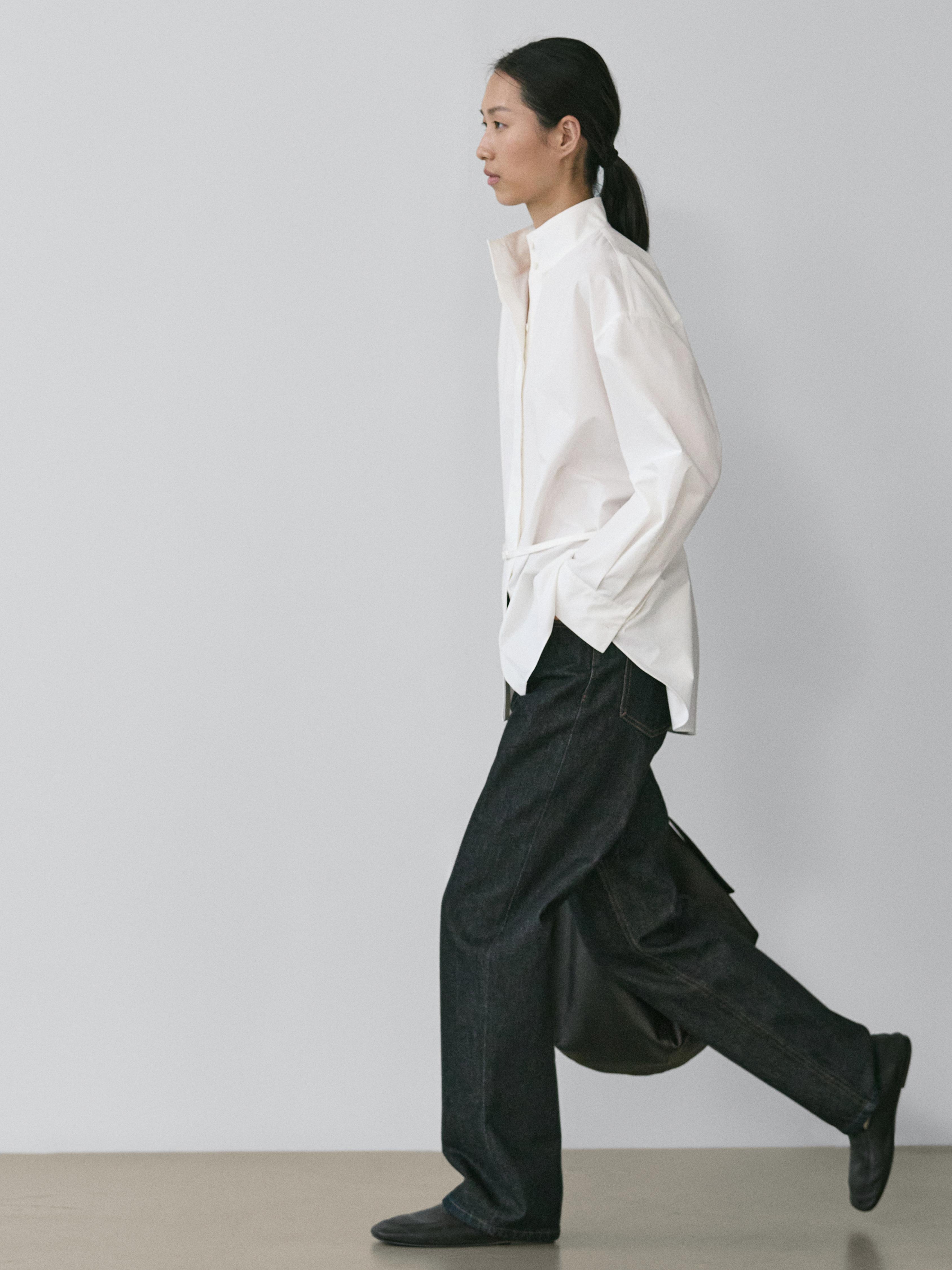 Conjunto de camisa blanca de manga larga y jeans azul oscuro de corte recto y tiro alto.