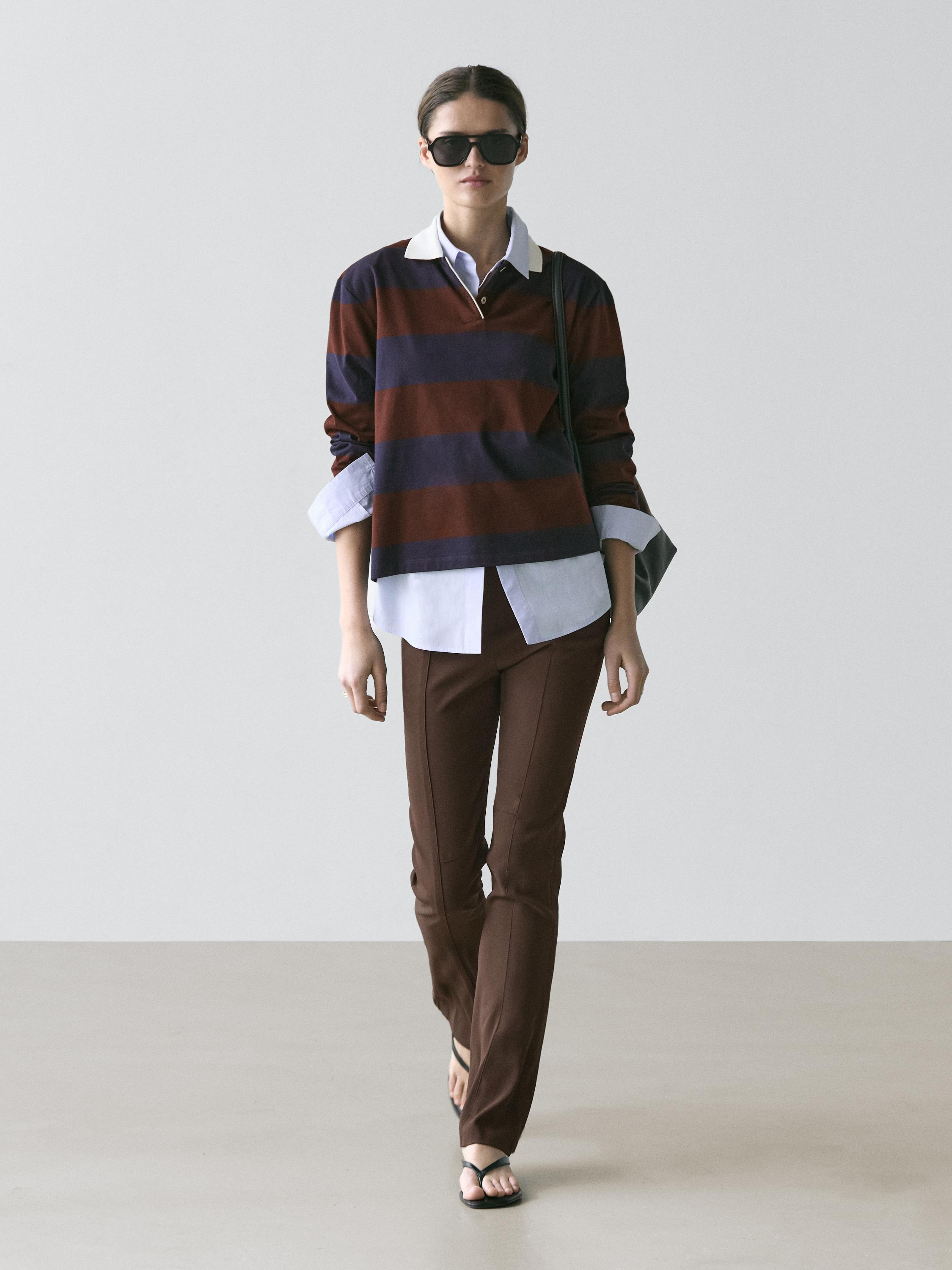 Navy and brown striped polo set with a white collar, white shirt underneath, and brown pants.
