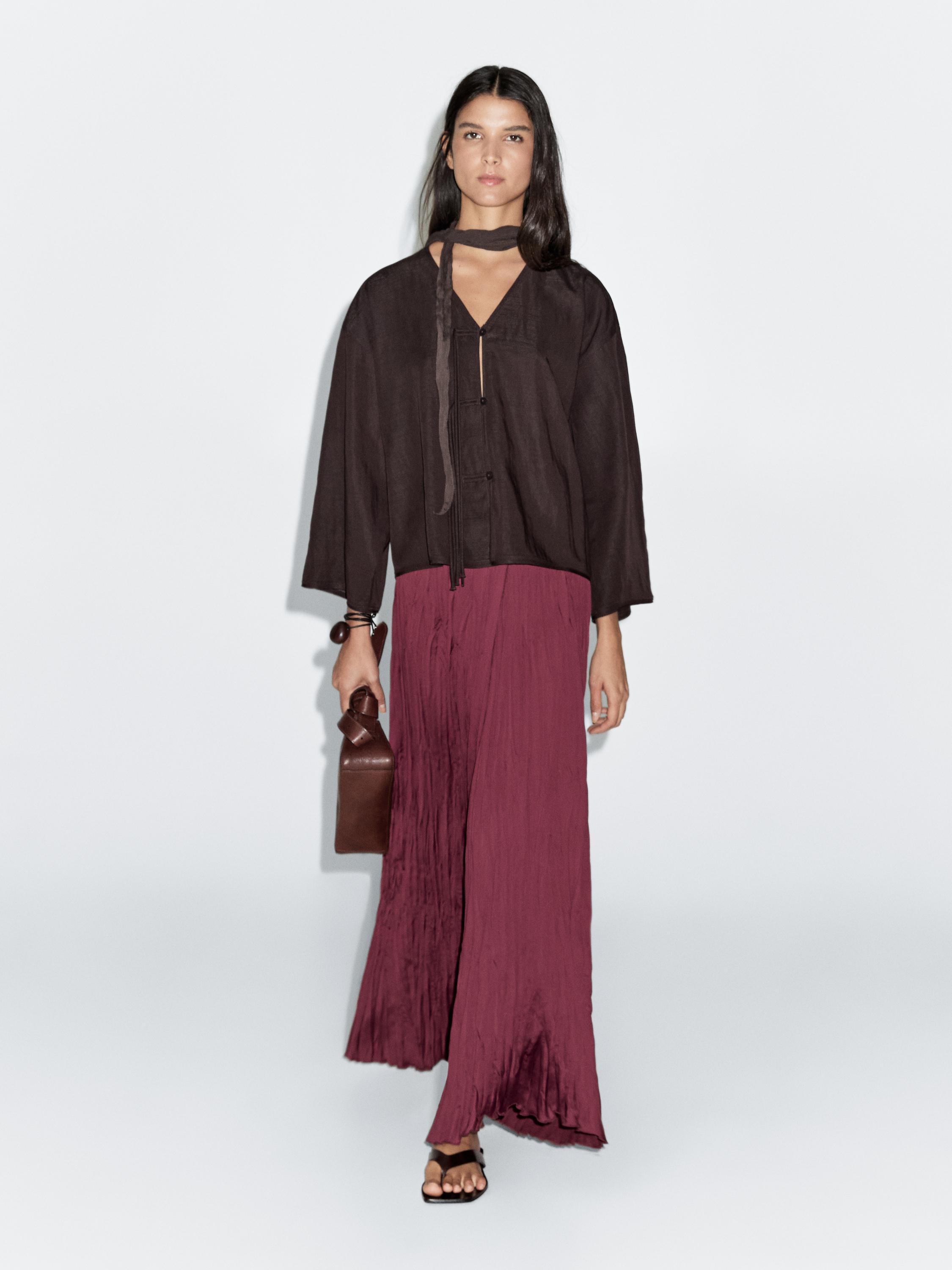 Set of long-sleeved black blouse and long pleated burgundy skirt