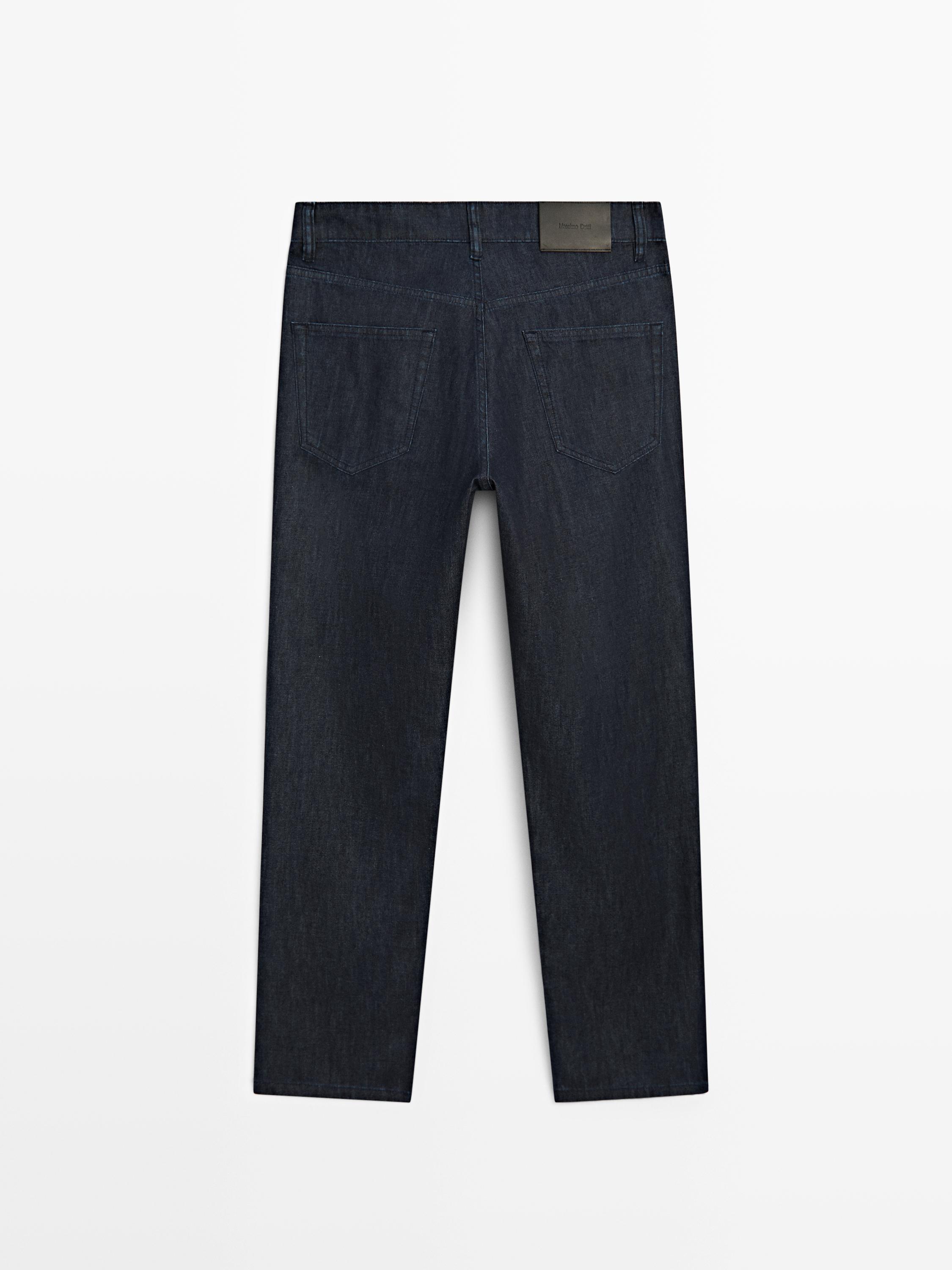 Widok z tyłu na dżinsy tapered fit w kolorze granatowym z tylnymi kieszeniami.