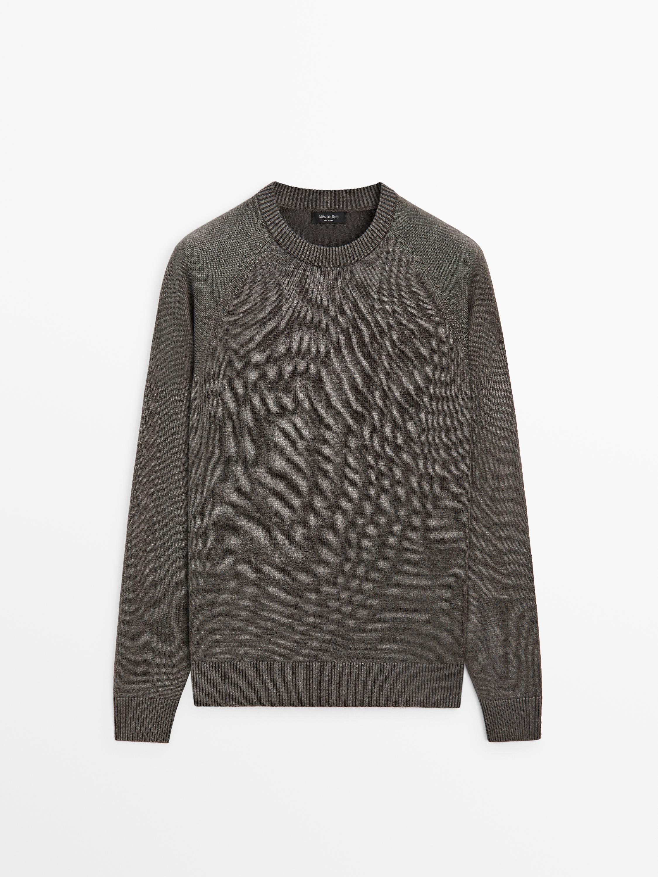 Vooraanzicht van een grijsgroene trui met ronde hals en lange mouwen. Geribbelde manchetten en zoom.