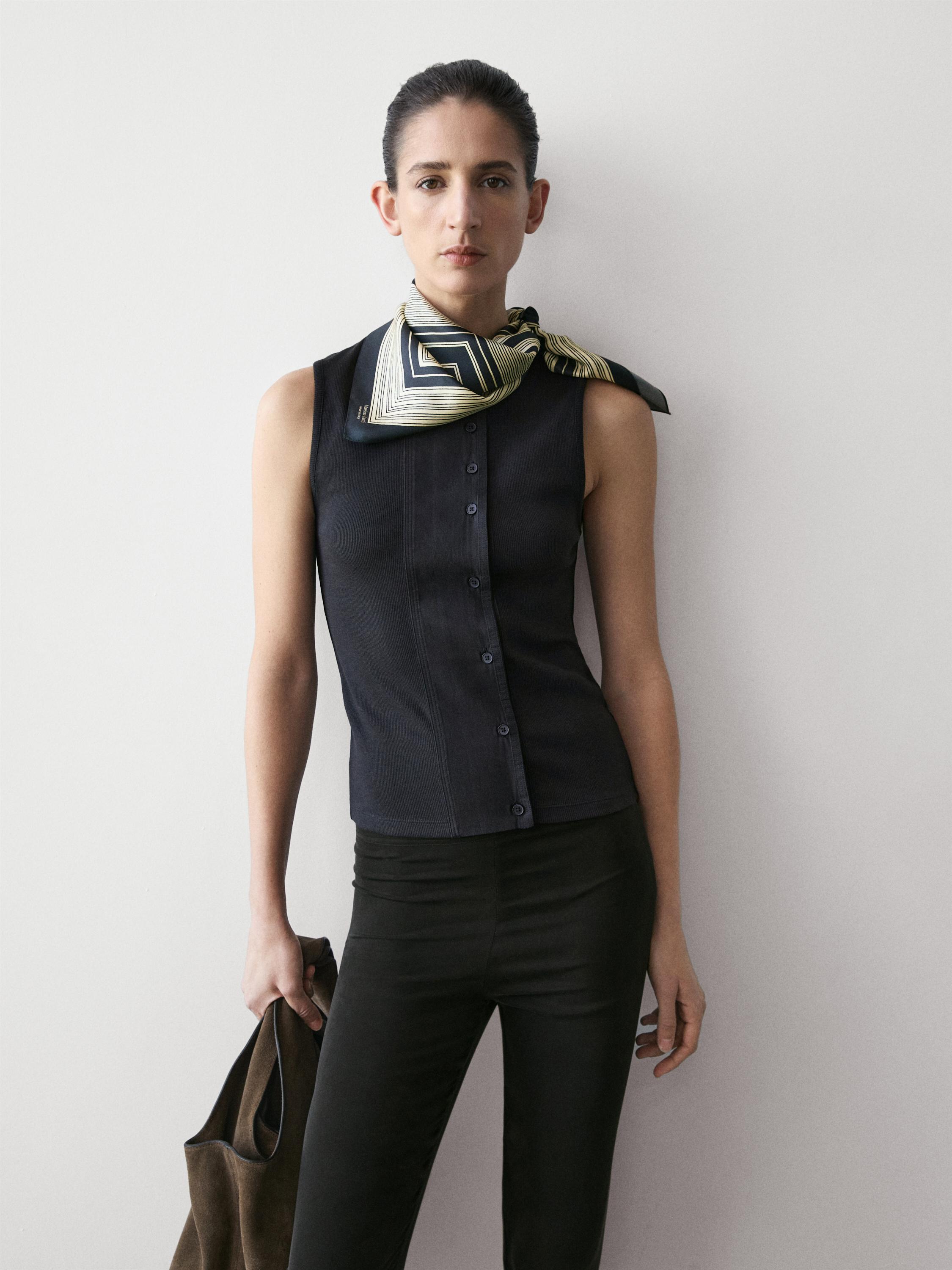 Bordo önü düğmeli lacivert atlet ve siyah pantolon takımı. Boyunda desenli fular.