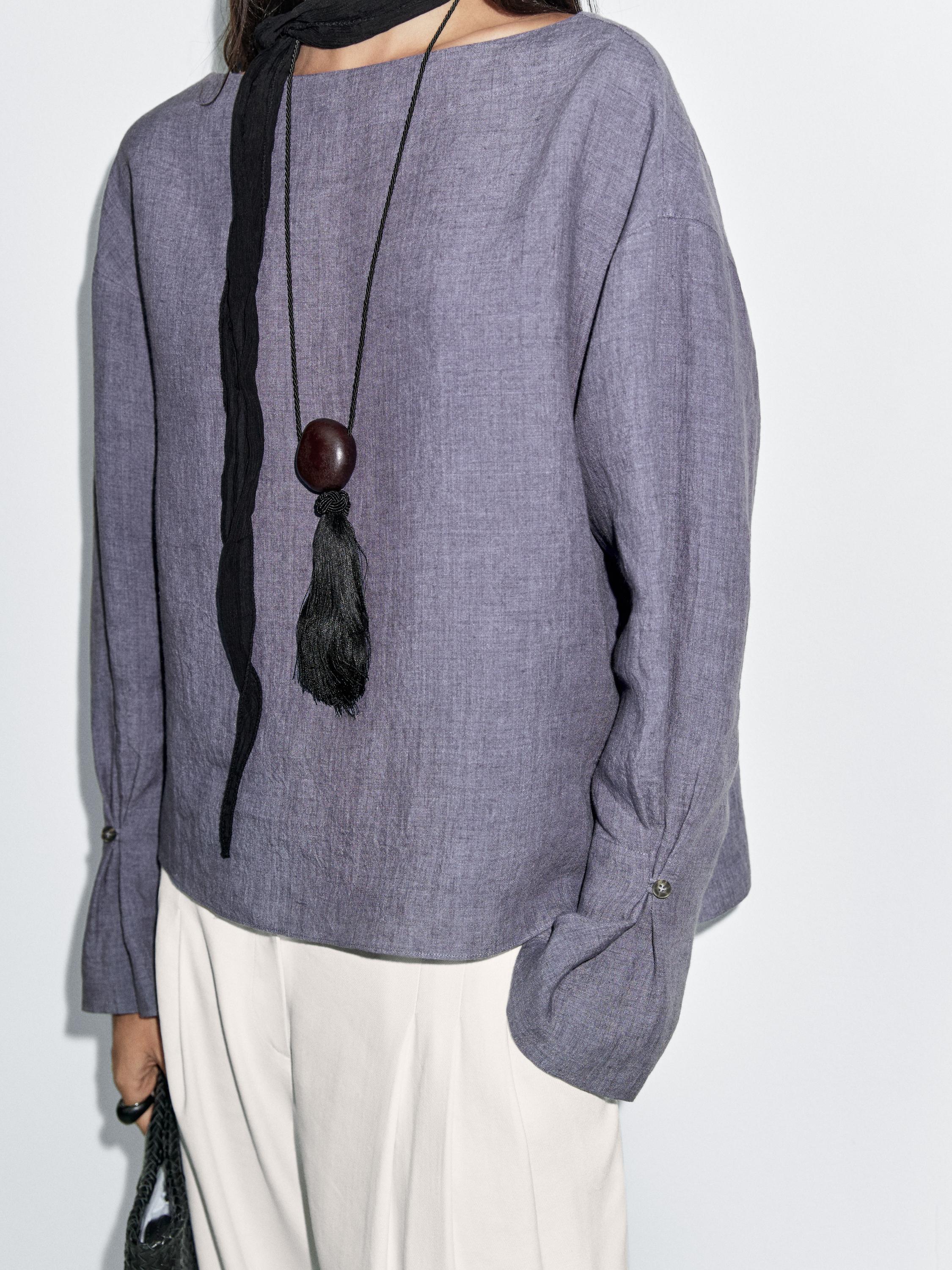 بلوزة بفتحة صدر على شكل V وتفصيل على الأكمام