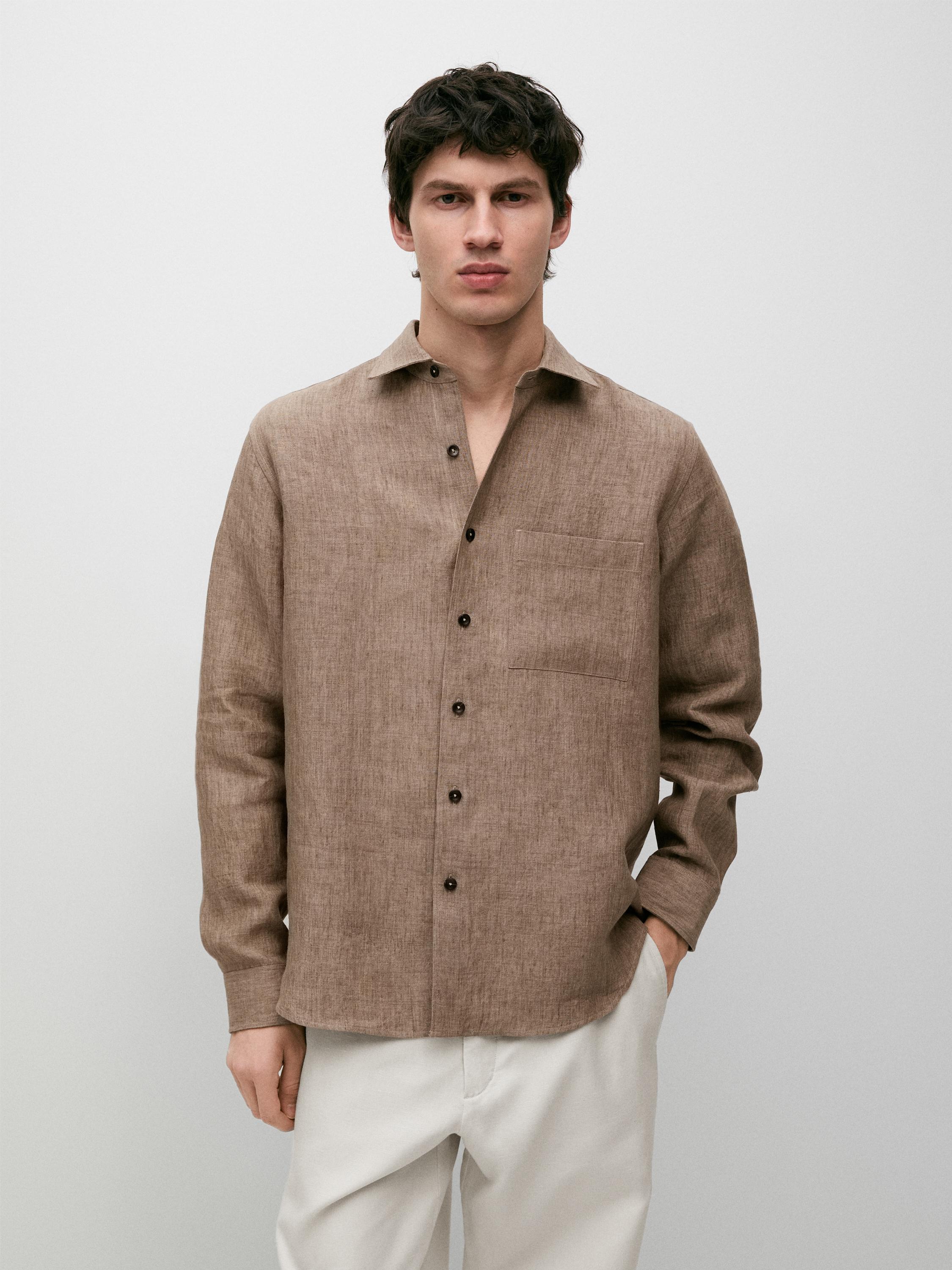 Conjunto de camisa beige de manga larga con bolsillo frontal y botones oscuros, combinada con pantalones claros.