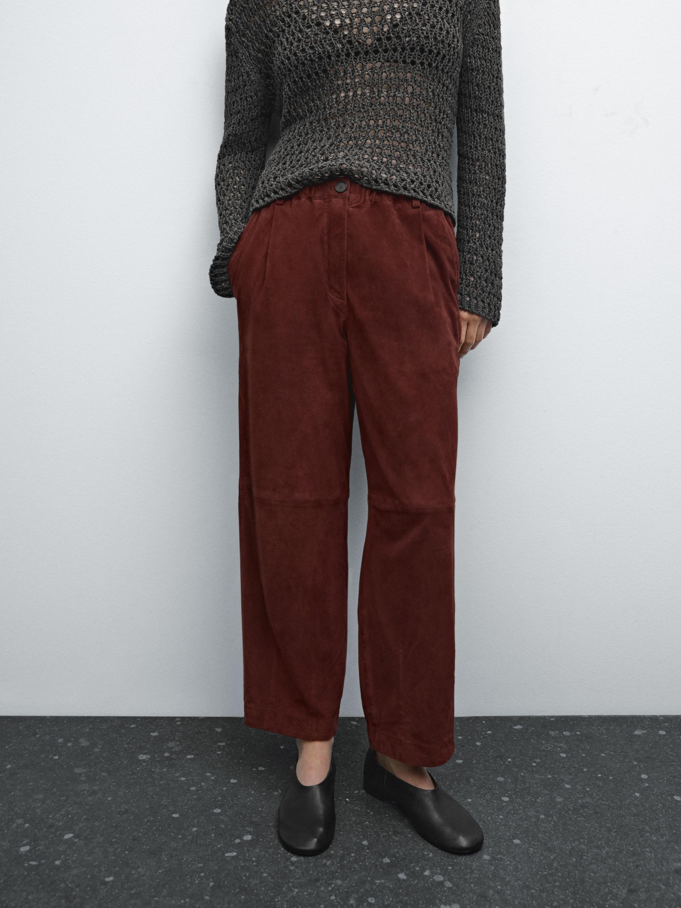 Ensemble composé d'un pantalon marron à jambes larges et d'un pull gris foncé en maille ajourée.