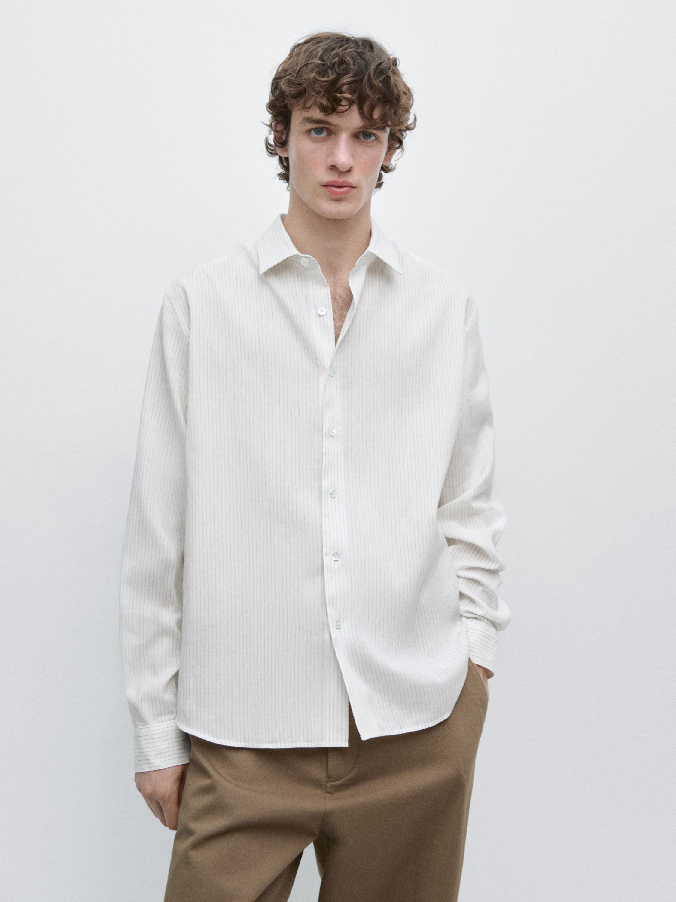 Conjunt de camisa de ratlles blanques de màniga llarga i pantaló marró.