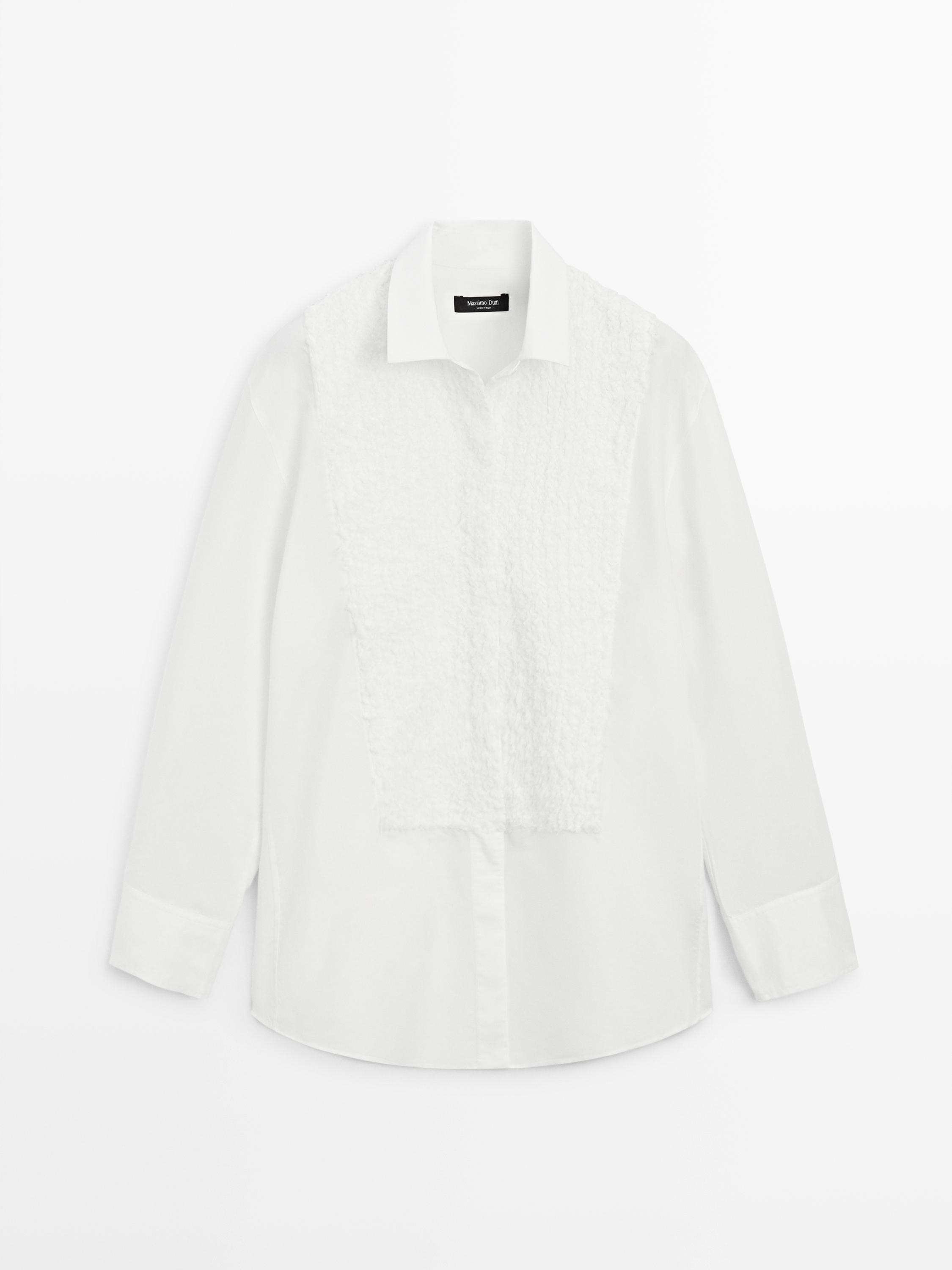 Front view of a white shirt with embroidered detailing on the bib, classic collar, and long sleeves.
