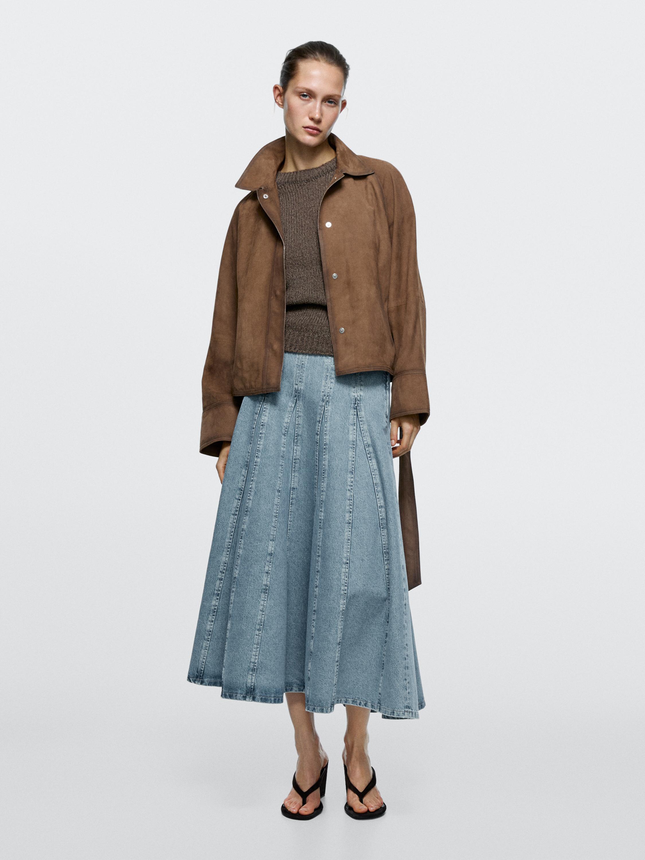 Set bestehend aus brauner Jacke, braunem Pullover und hellblauem Godet-Midi-Jeansrock.