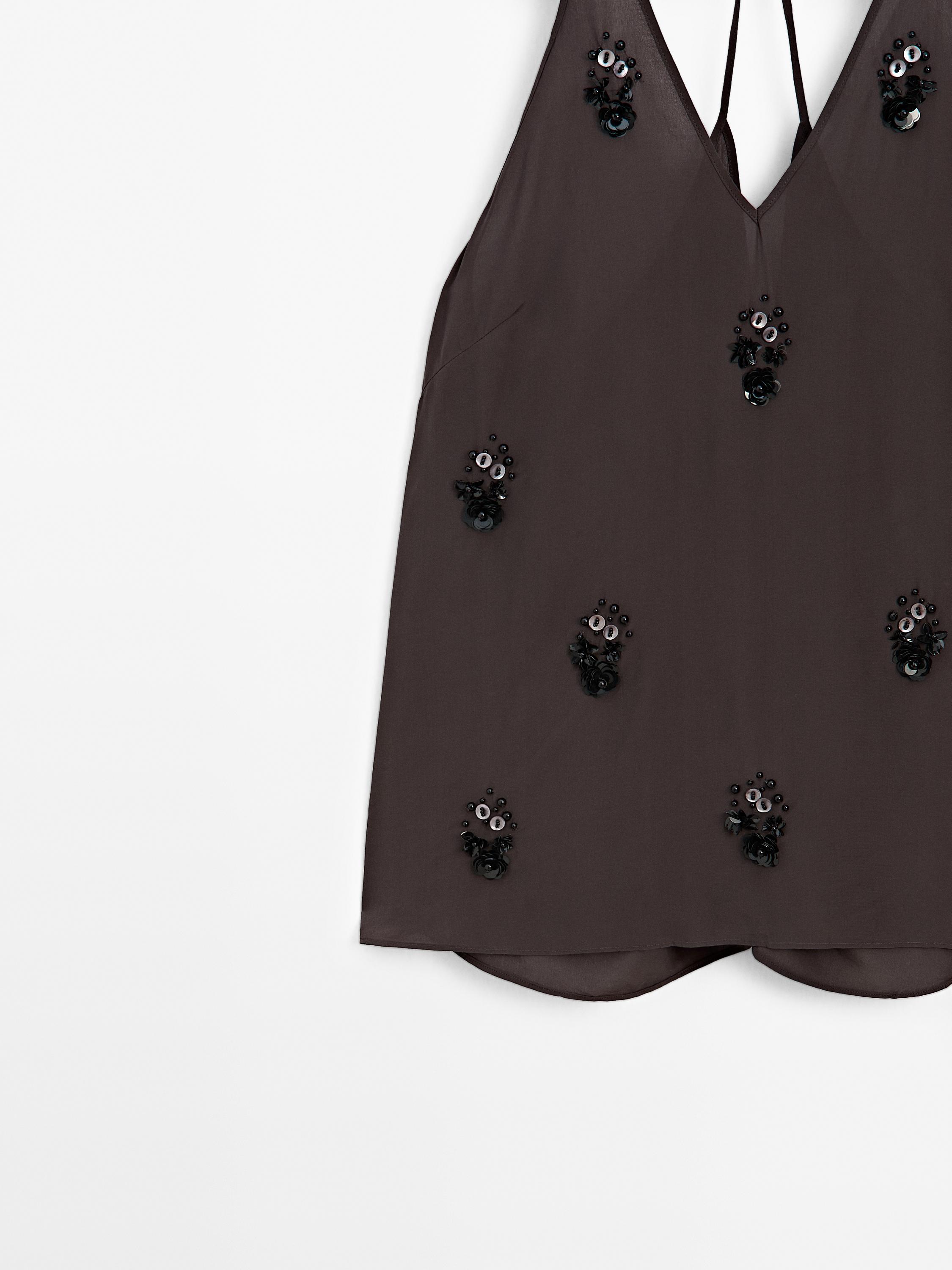 Flowing top with floral appliqués