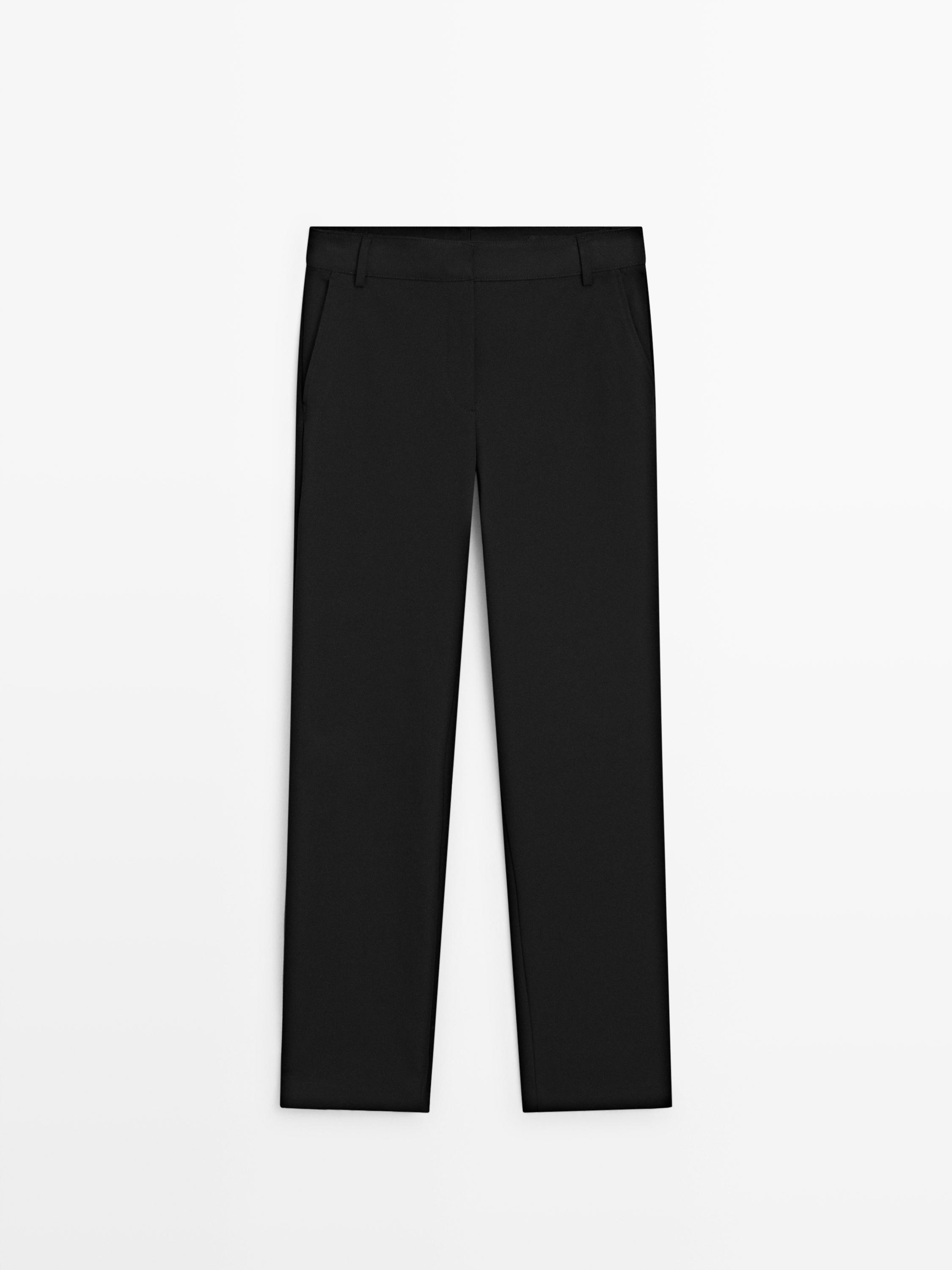 Vue de face d'un pantalon noir straight fit avec poches latérales et passants de ceinture.