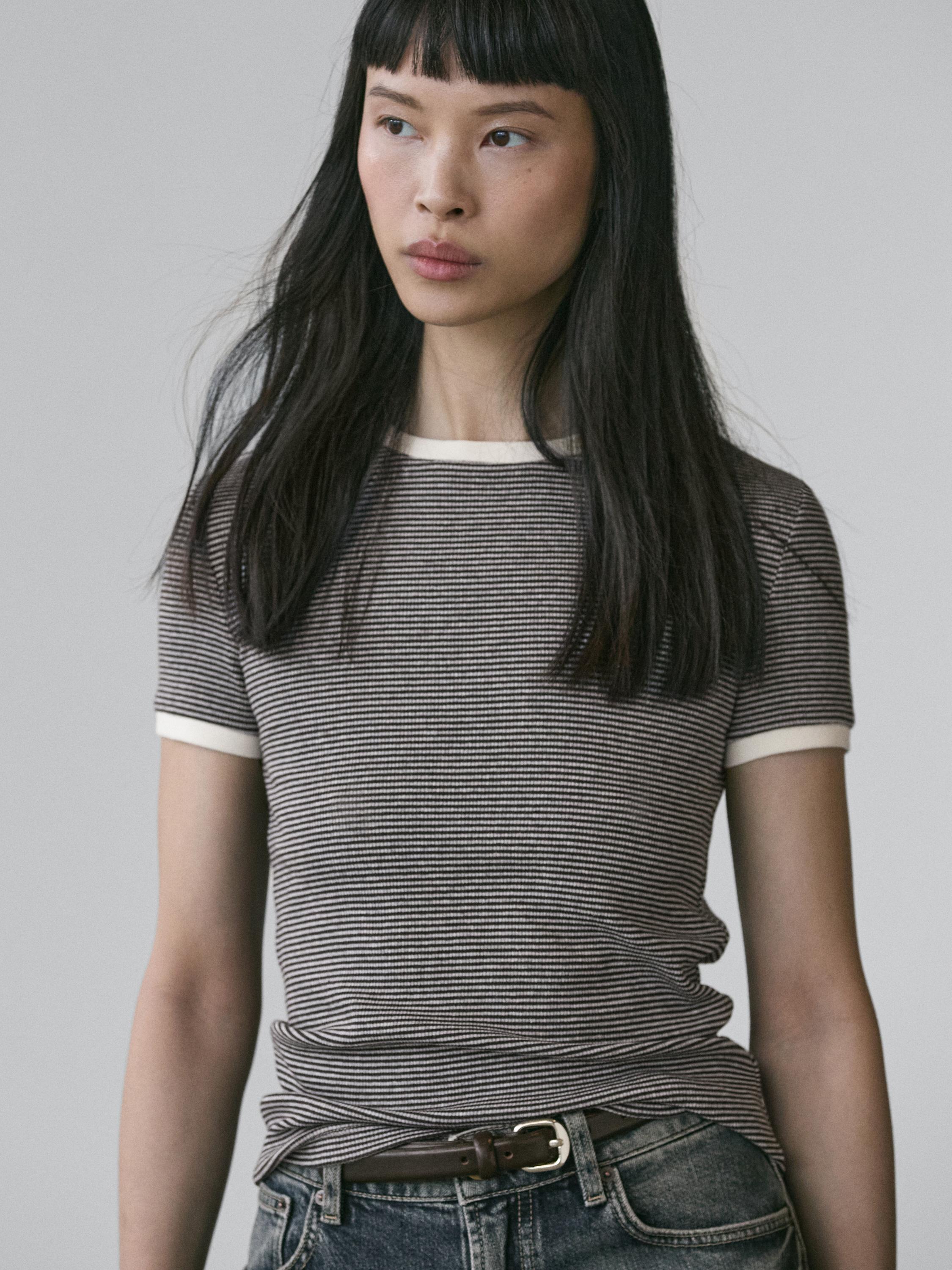 ภาพกลางของเสื้อยืดสีเทาลายทางเล็กๆ แขนสั้น มีขอบสีขาวที่คอและแขนเสื้อ