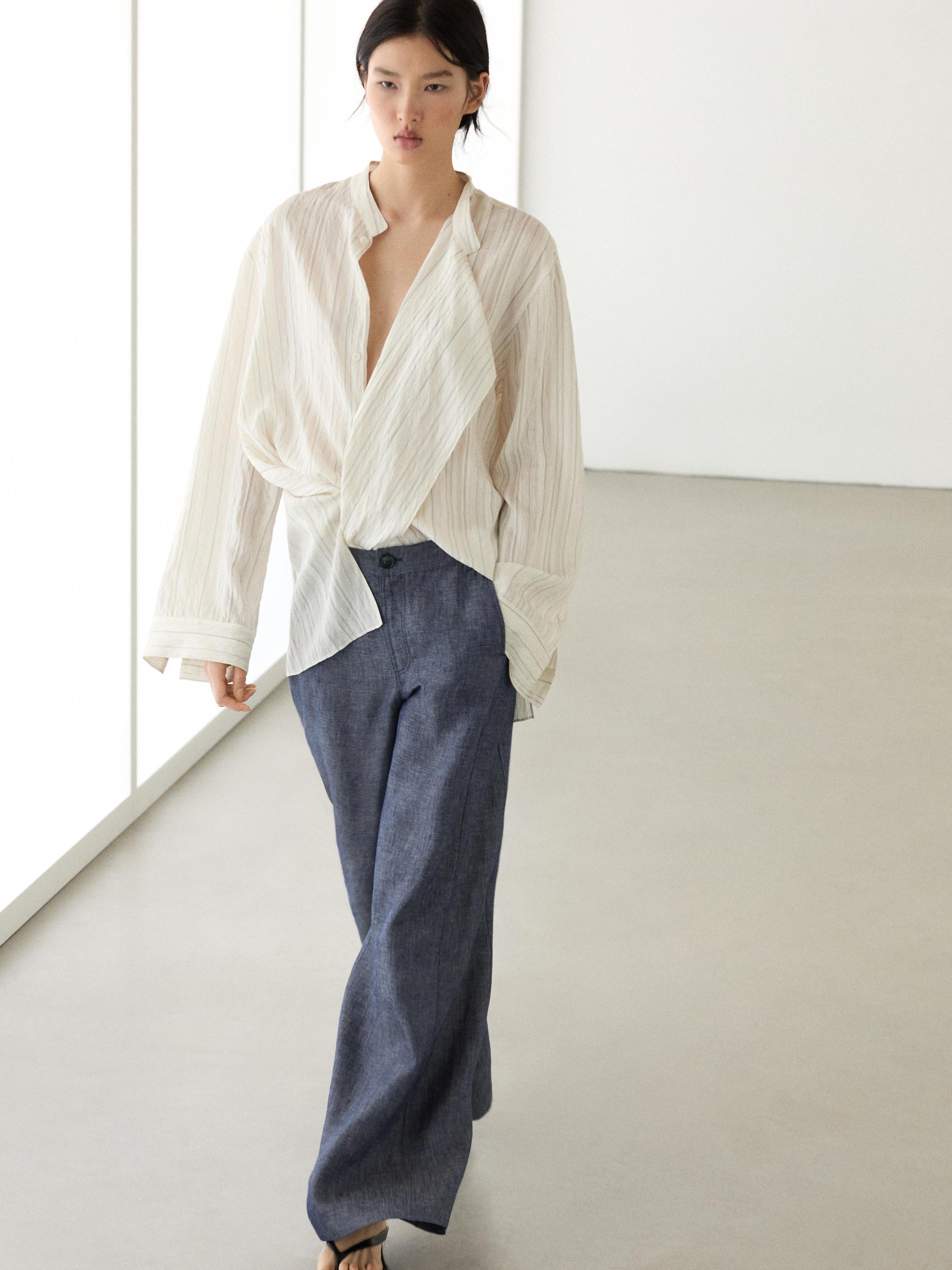 Dark blue palazzo pants set with a white striped V-neck blouse and long sleeves.