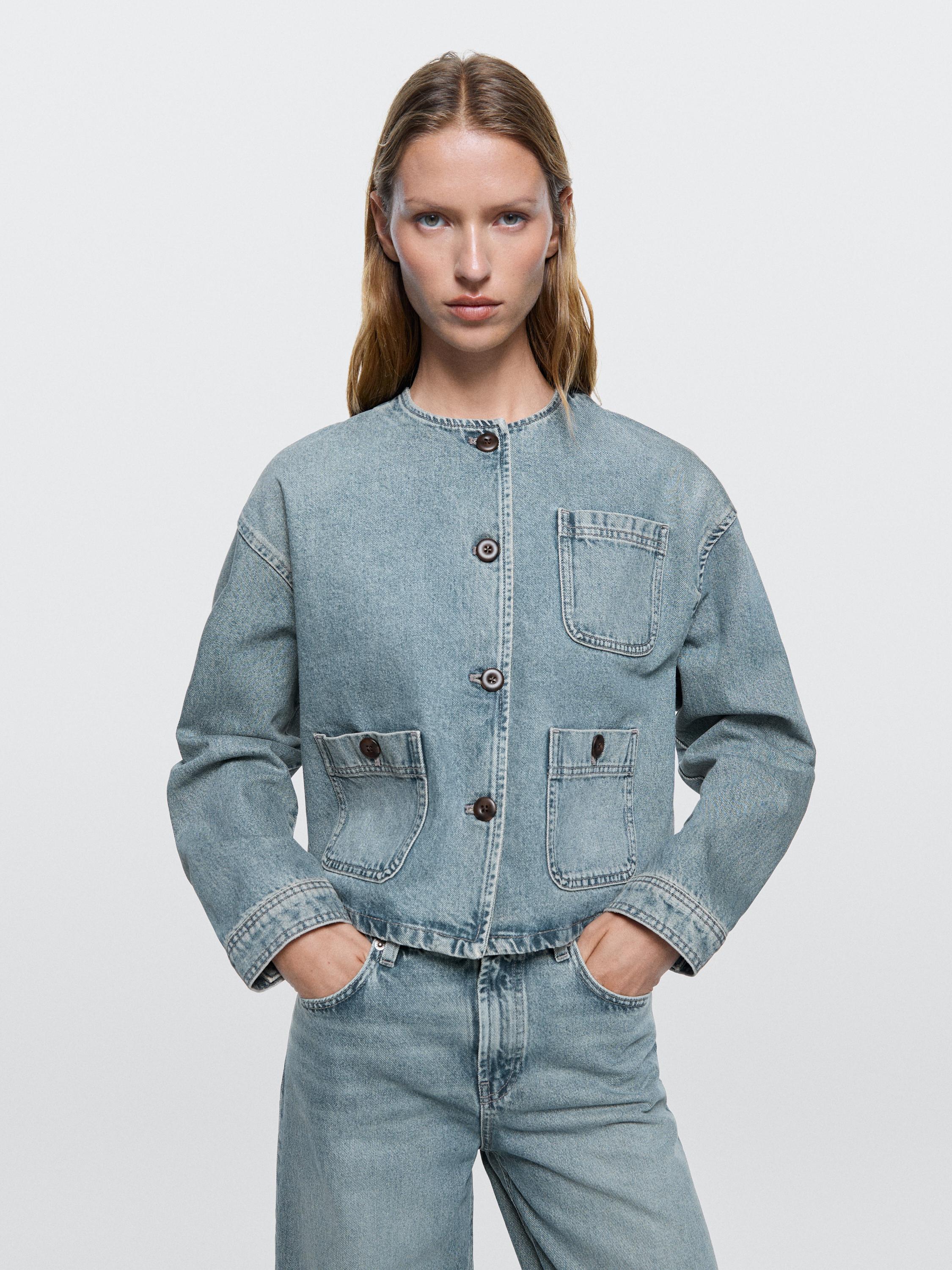 Lichtblauwe denim jas met knopen aan de voorkant en borst- en zijzakken, gecombineerd met een bijpassende broek.