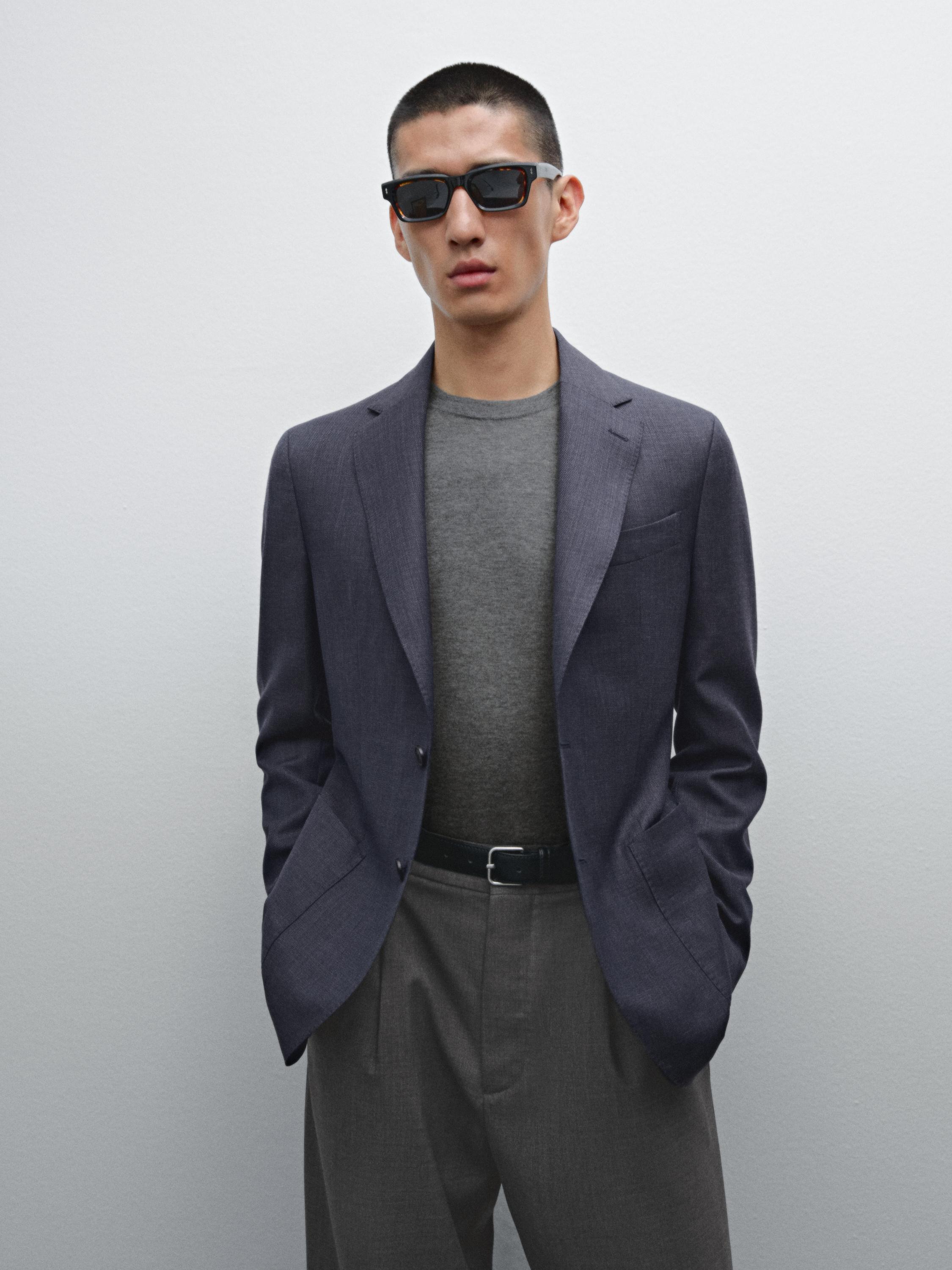 طقم يتكون من سترة رمادية داكنة، وقميص رمادي، وبنطلون رمادي مع حزام أسود