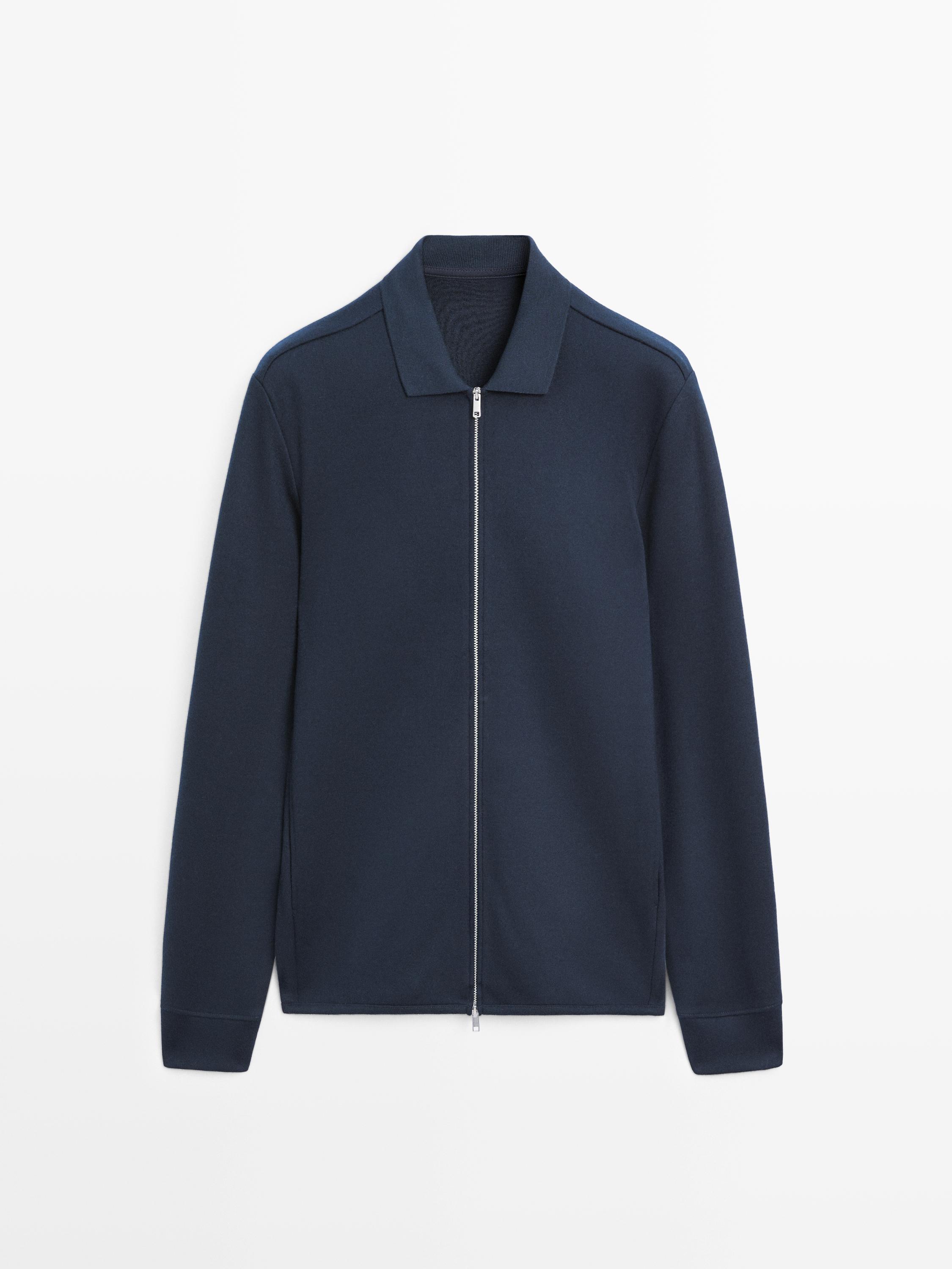 Vista frontal de chaqueta azul marino con cremallera central y cuello clásico.