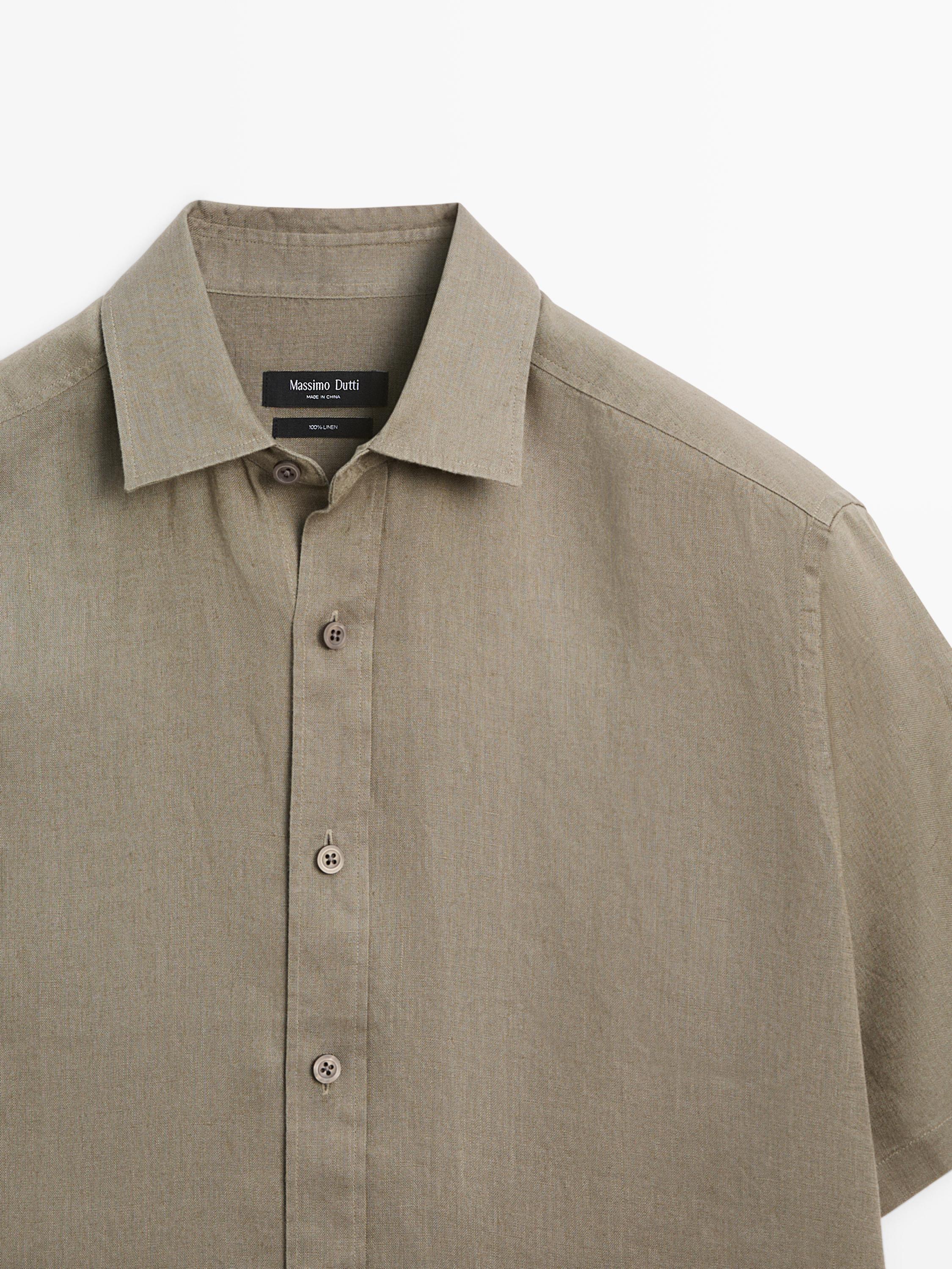 "Plan moyen de chemise couleur sable à manches courtes avec col classique et boutonnage sur le devant."