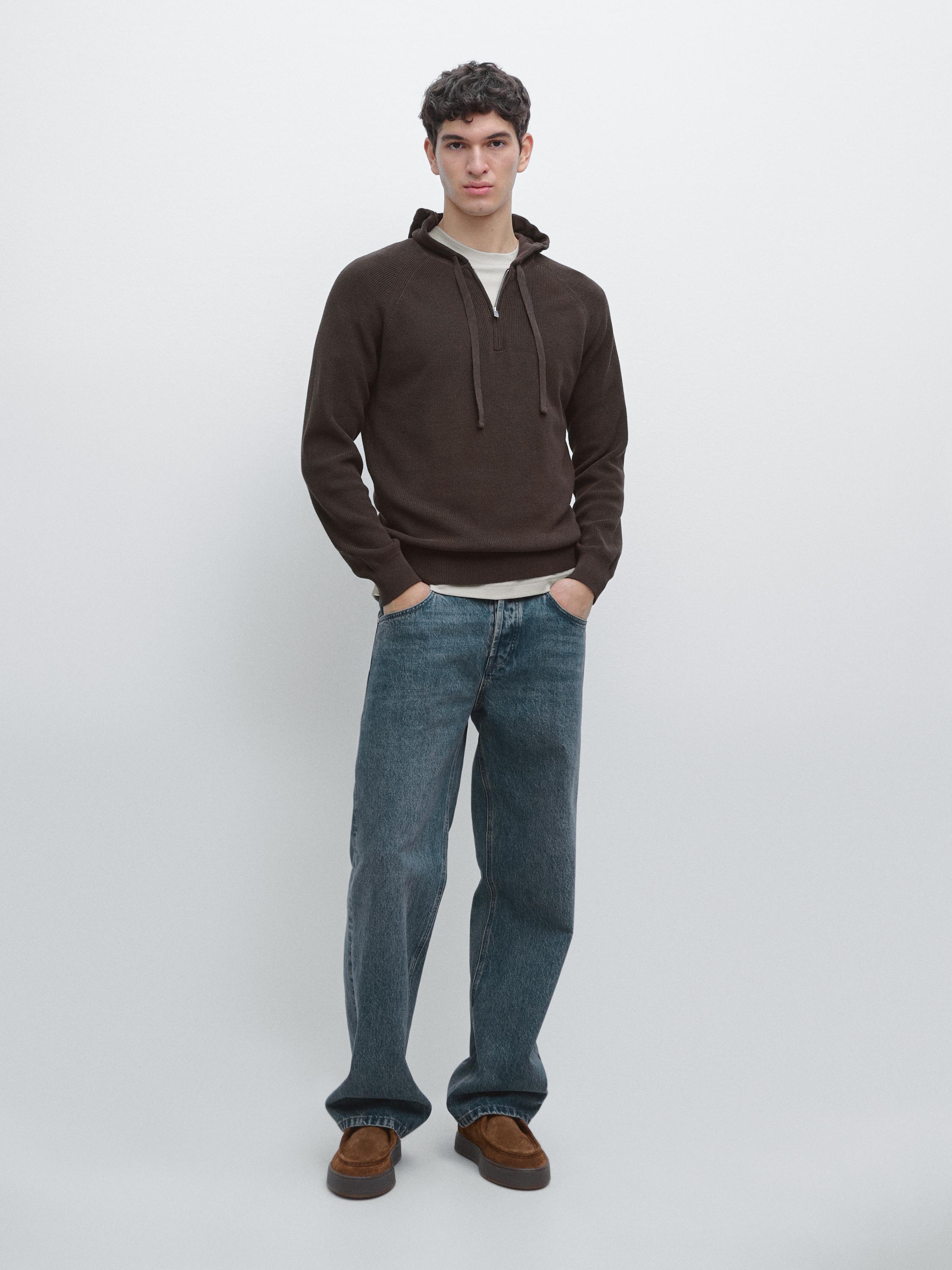 Ensemble sweat à capuche marron et jean bleu.