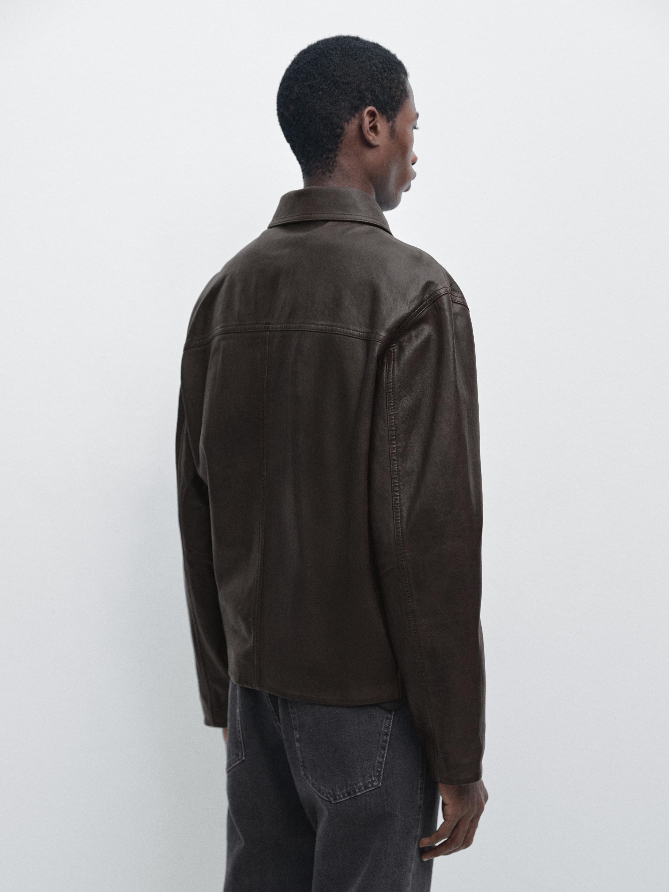 Widok z tyłu brązowej kurtki ze sztucznej skóry nappa z klasycznym kołnierzem i widocznymi szwami.