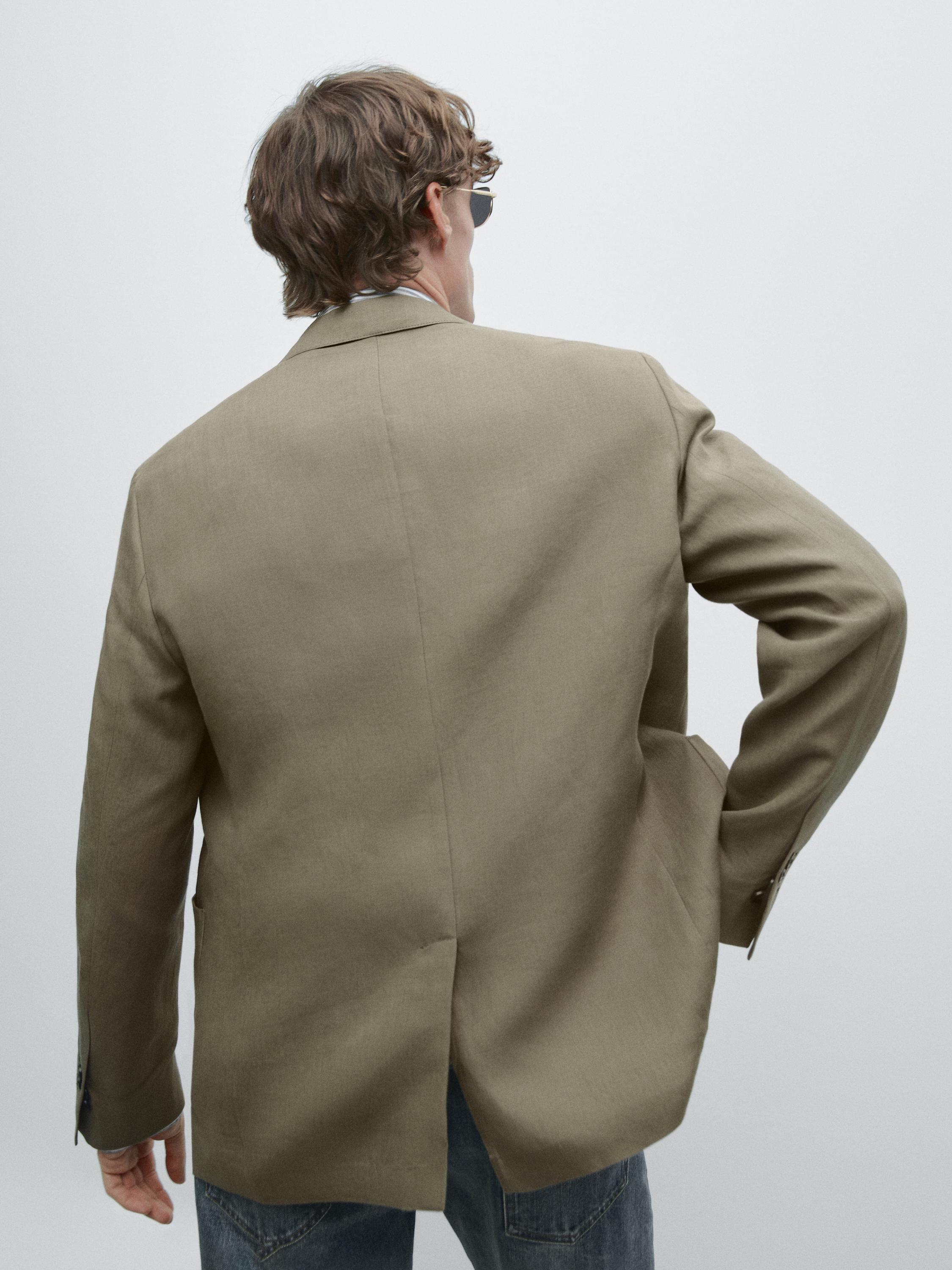 Rear view of greenish blazer with back slit and side pockets.