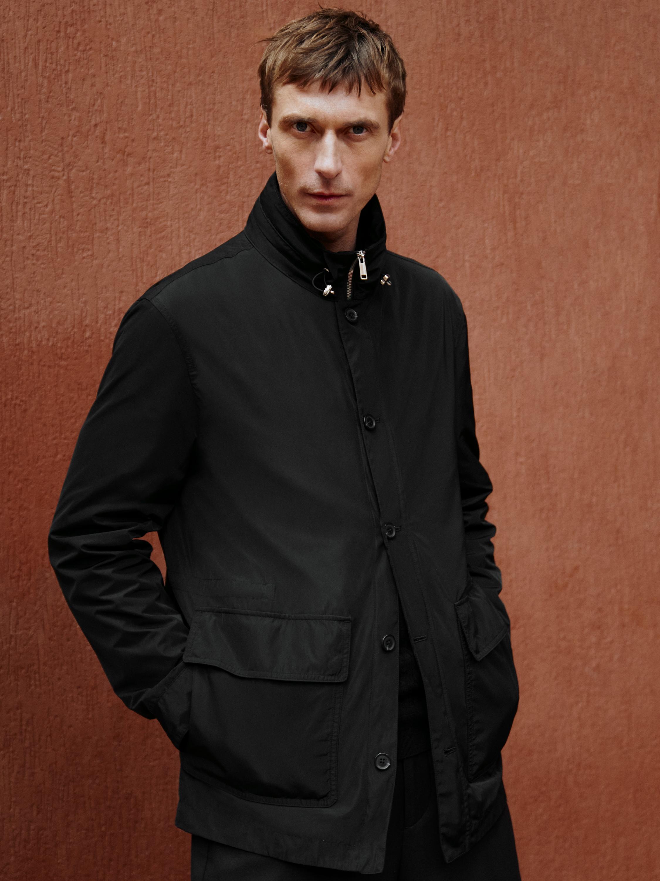 Black jacket set with hood and front flap pockets, button and zipper closure.