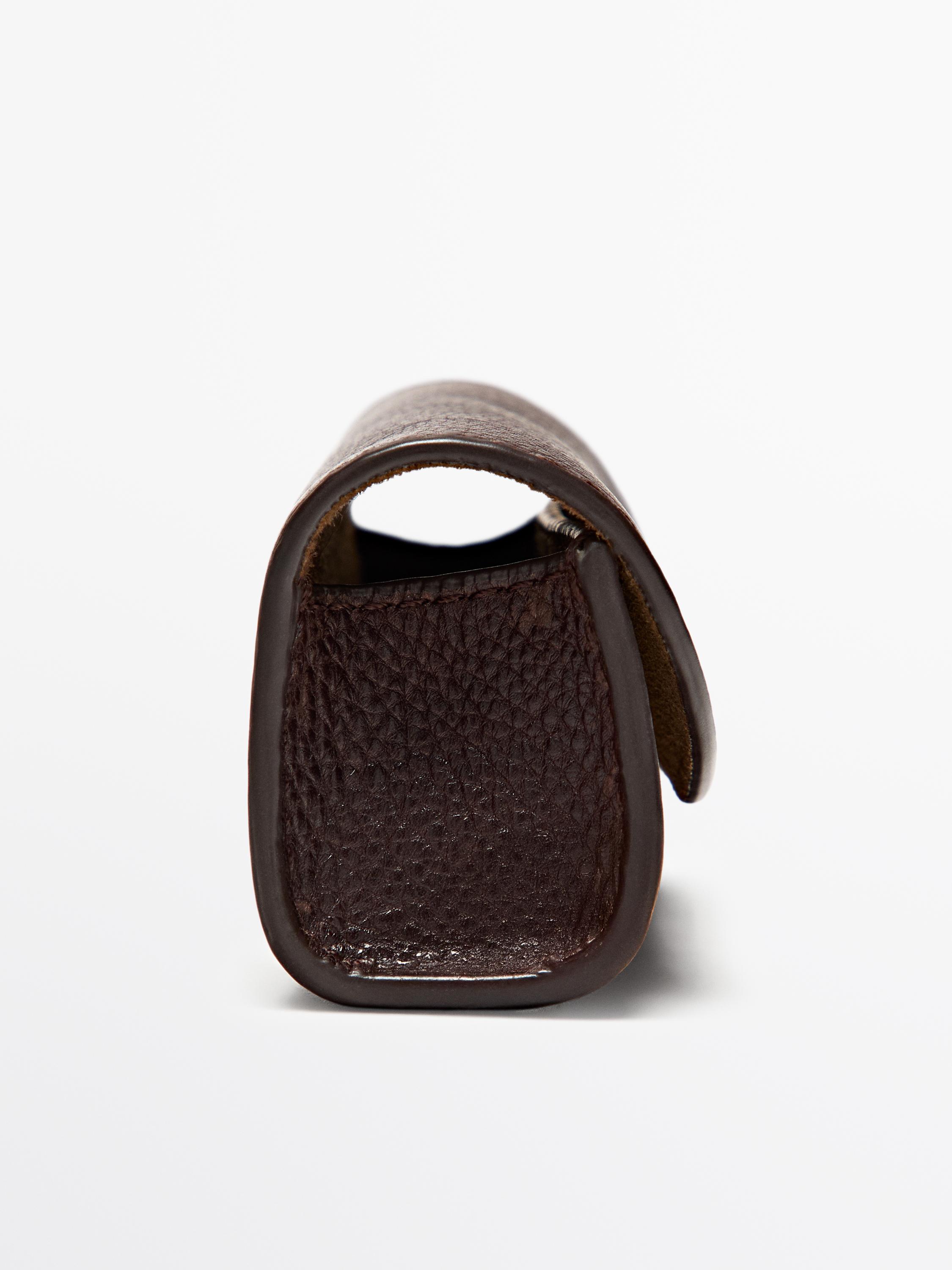 Боковой вид кошелька шоколадного цвета с зернистой текстурой.