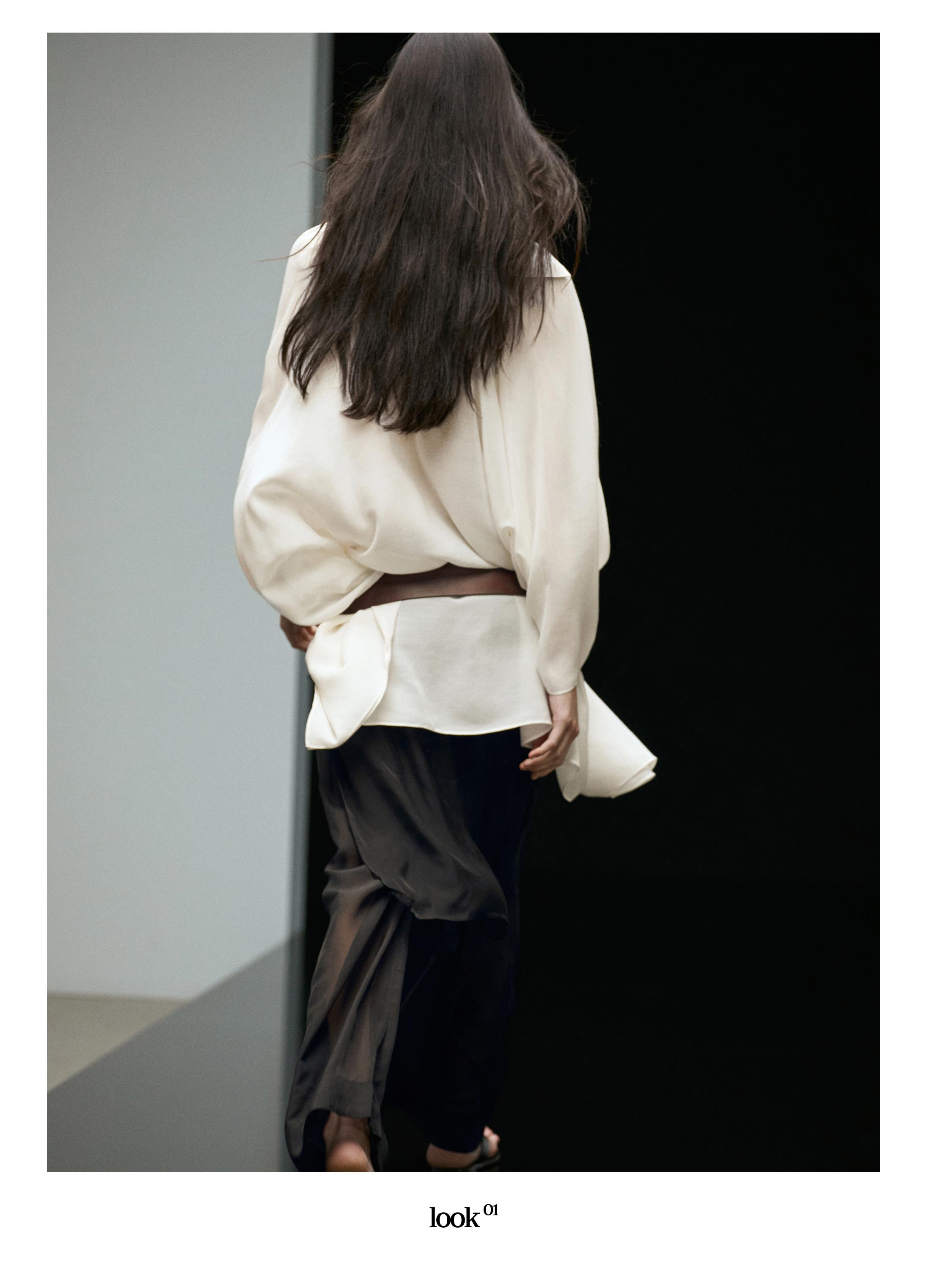 Conjunto de blusa blanca suelta y falda pantalón negra larga, vista posterior.