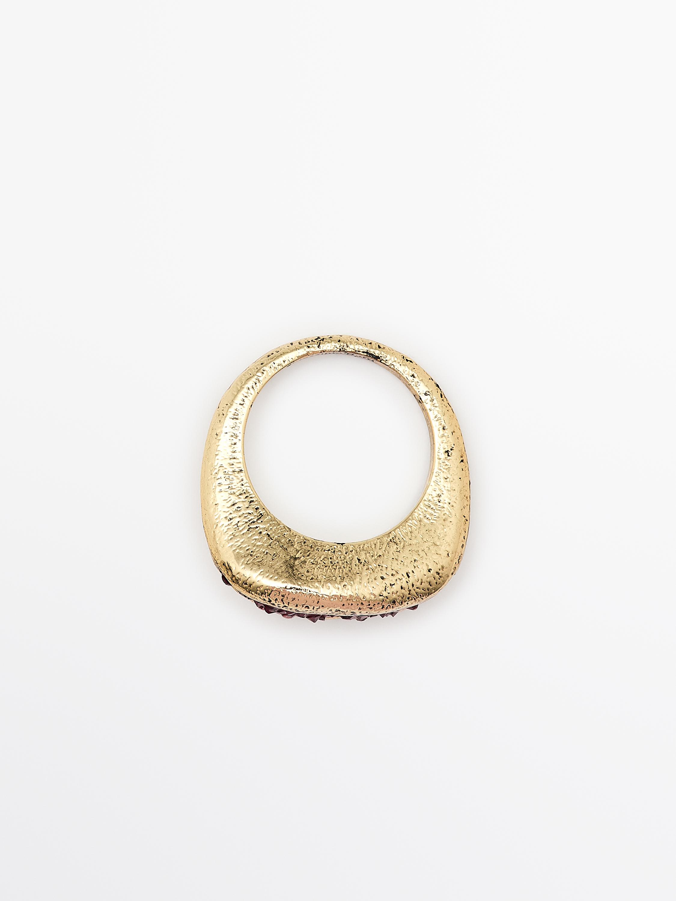 Front view of gold ring with irregular design and rough texture.