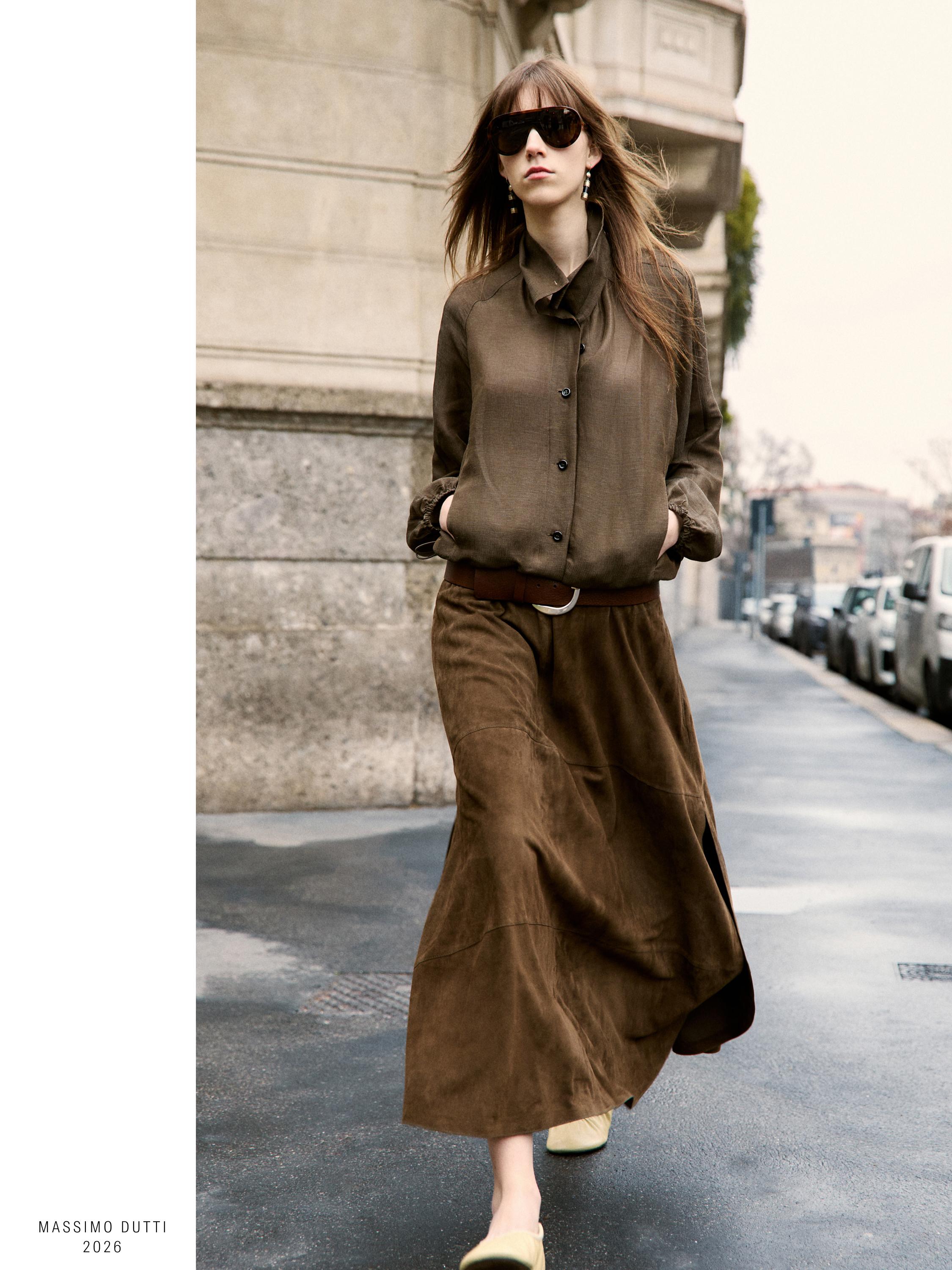 Ensemble jupe longue et blouse marron boutonnée. Poches latérales visibles sur la blouse.