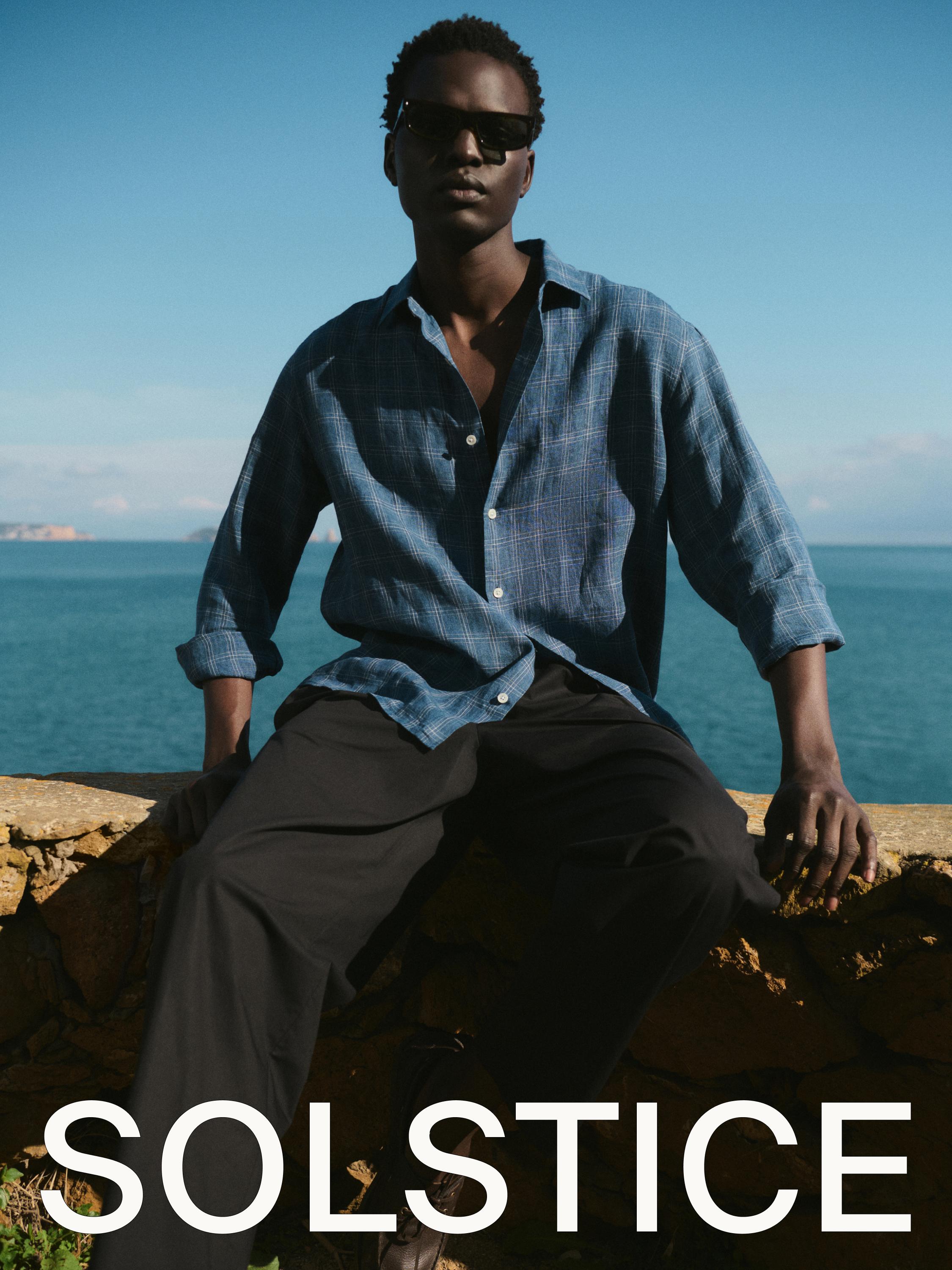 Conjunto de camisa azul de cuadros y pantalones negros. Texto "SOLSTICE" en la parte inferior.