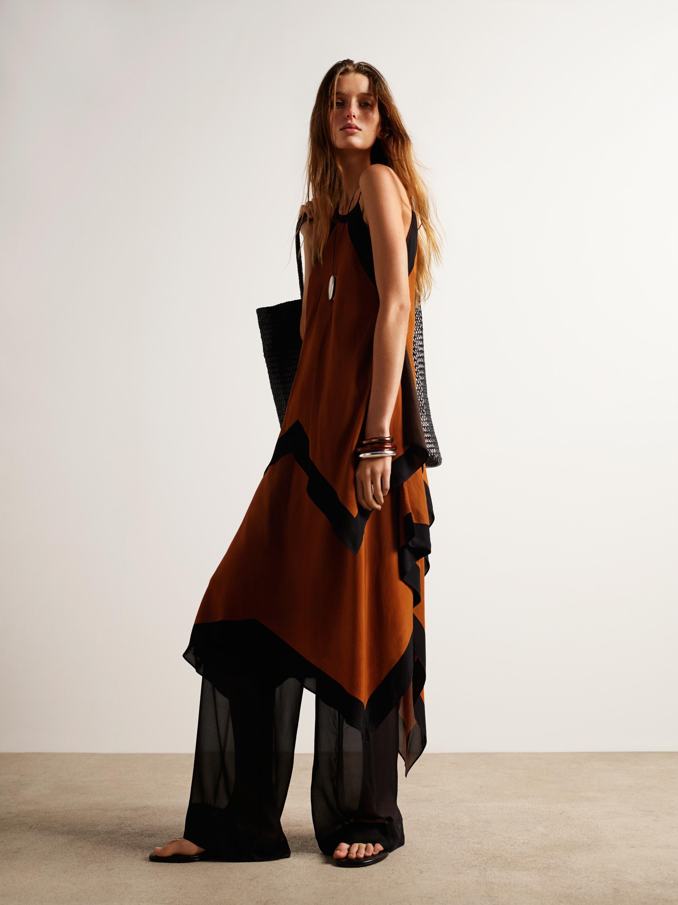 Σετ καφέ φορέματος με μαύρες λεπτομέρειες και μαύρο διάφανο παντελόνι.