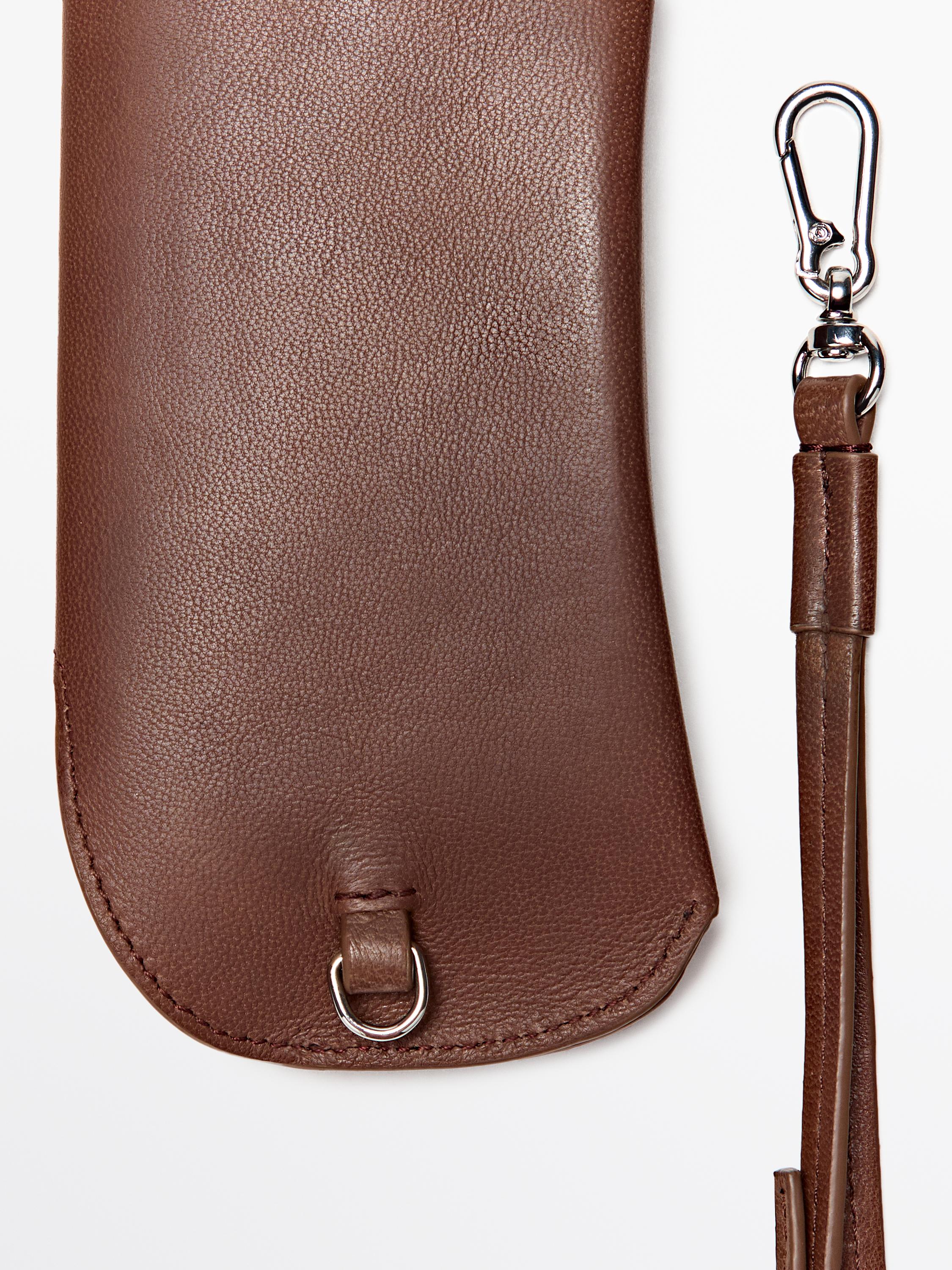 "Detail of brown purse with metal ring closure and detachable strap."