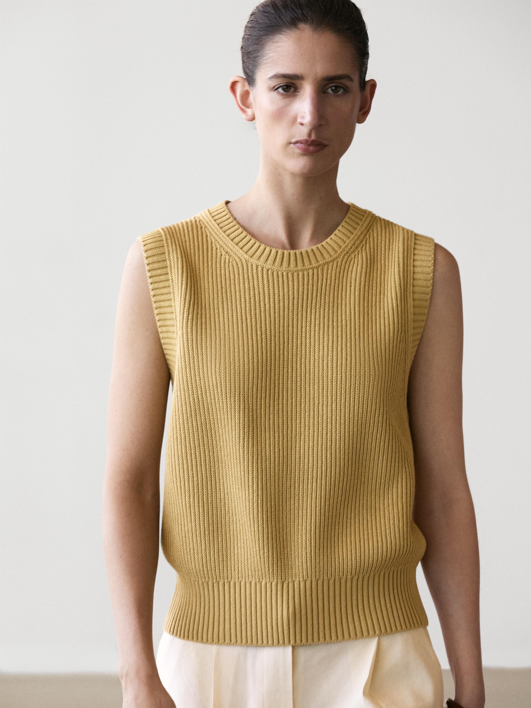 Plan moyen de gilet verdâtre en tricot avec col rond et sans manches.