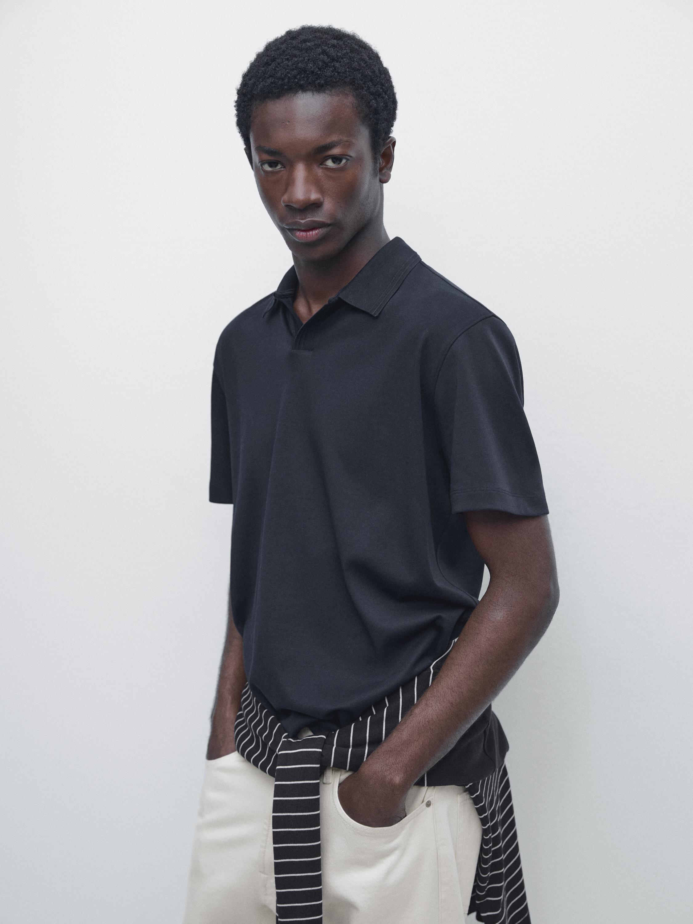 Medium shot of a navy blue short-sleeved polo shirt with a classic collar.