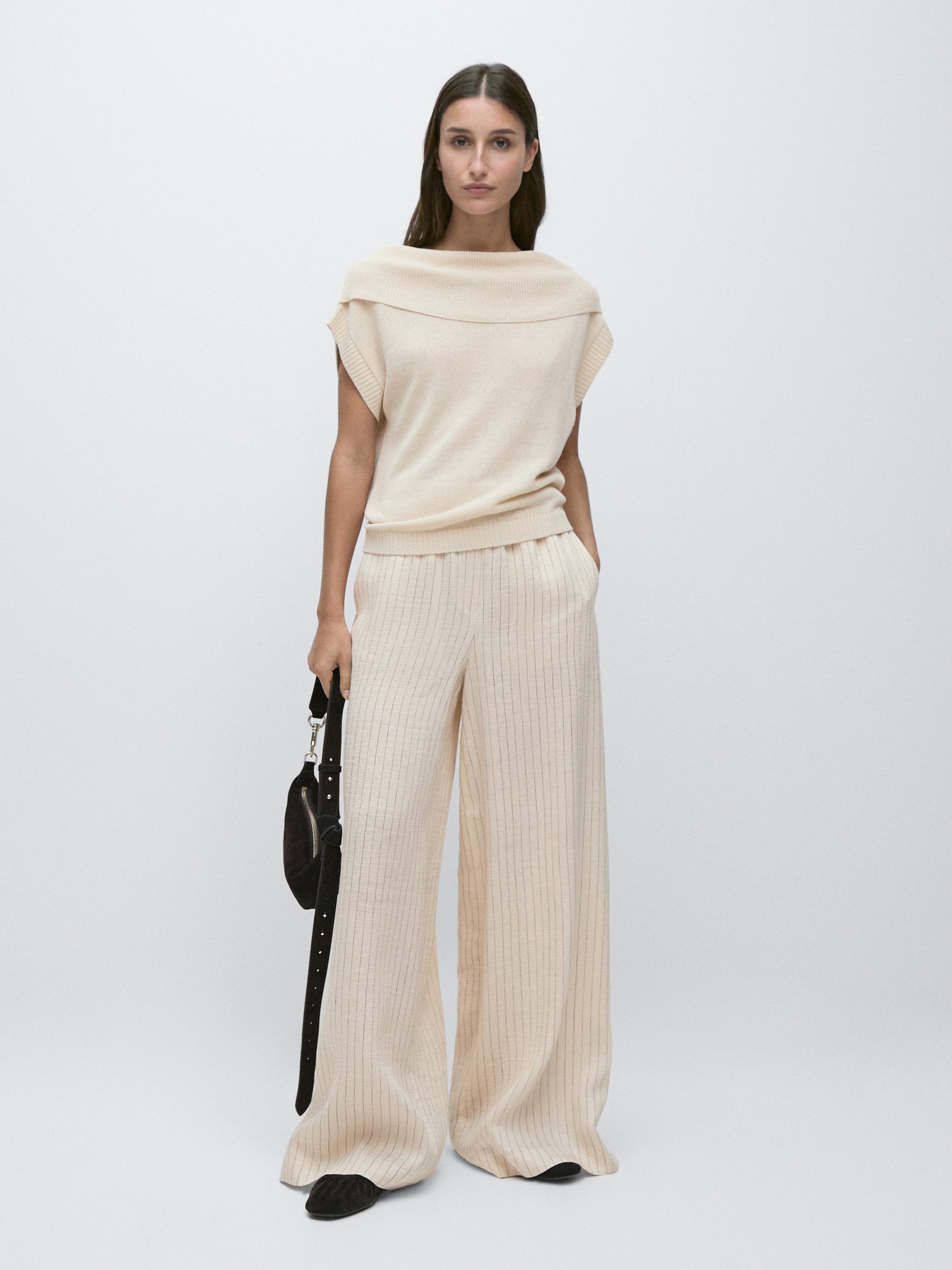 Conjunto de pantalón crudo de rayas diplomáticas y top sin mangas con cuello amplio. Bolsillos laterales visibles.