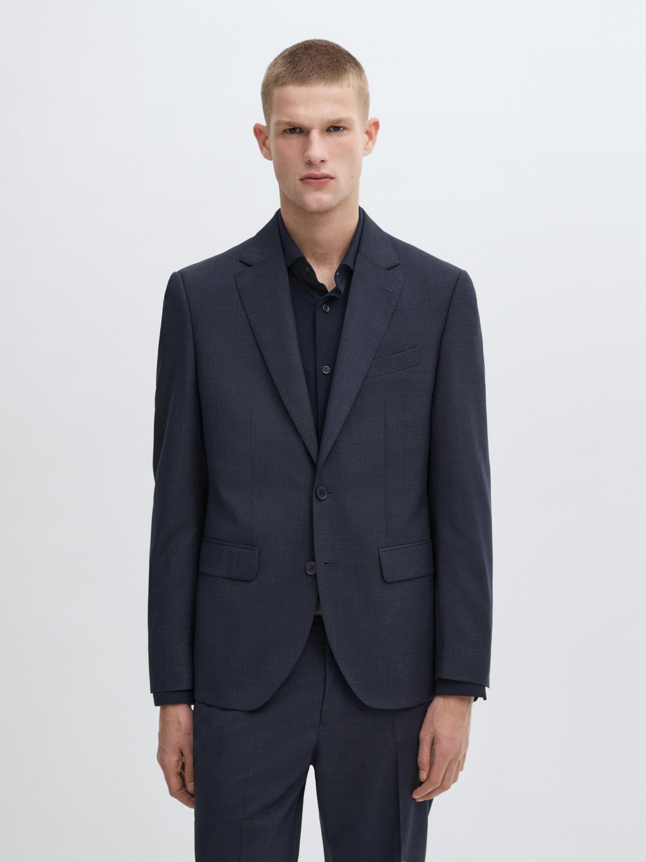 طقم بدلة زرقاء داكنة مع طية صدر السترة الكلاسيكية وزرين، قميص أسود ظاهر.