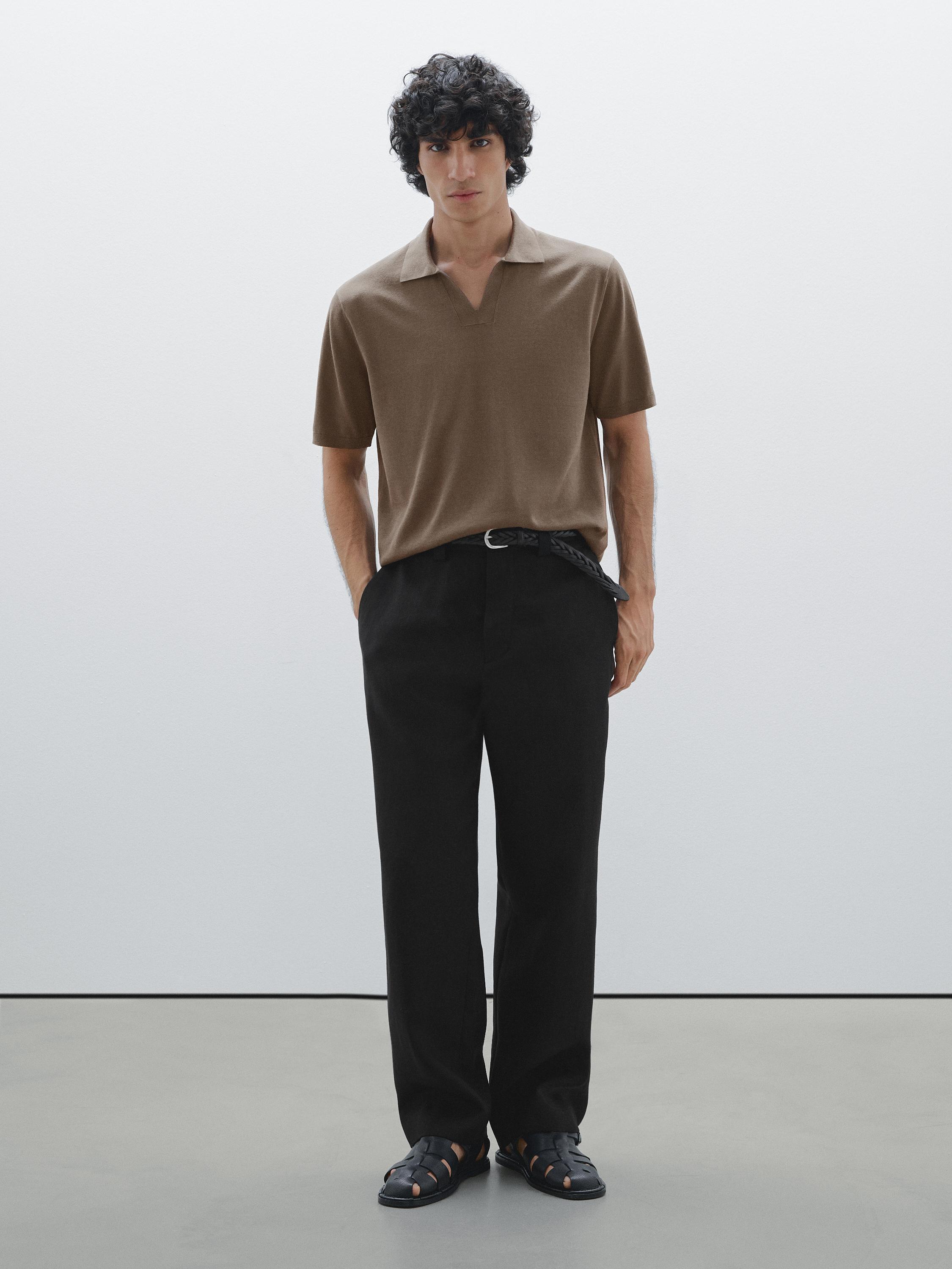 طقم مكون من قميص بولو بني وبنطلون أسود مع صندل داكن.