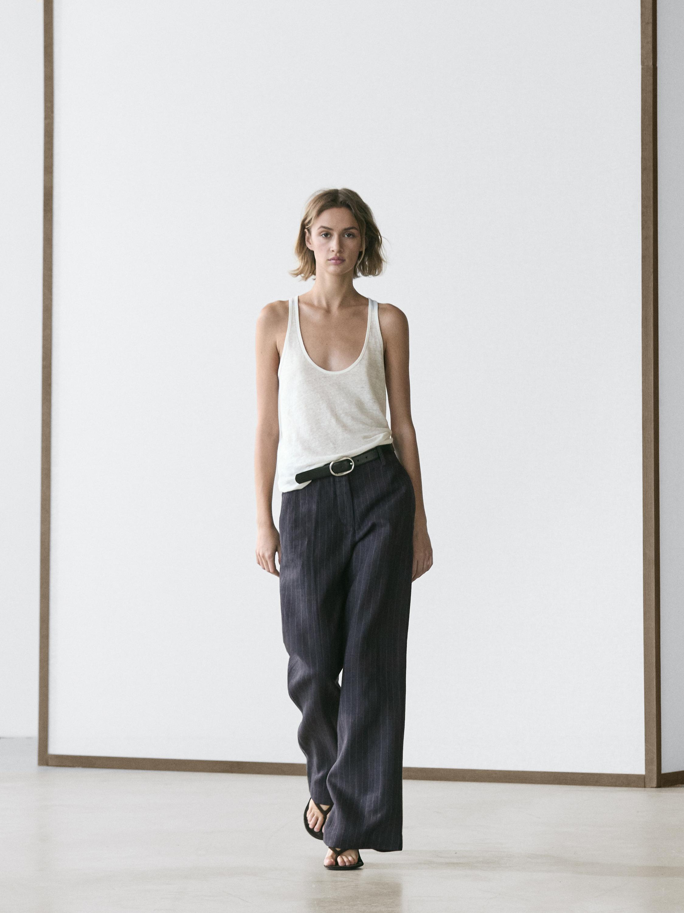 Conjunt de pantaló ample blau fosc amb ratlla diplomàtica i samarreta sense mànigues blanca.