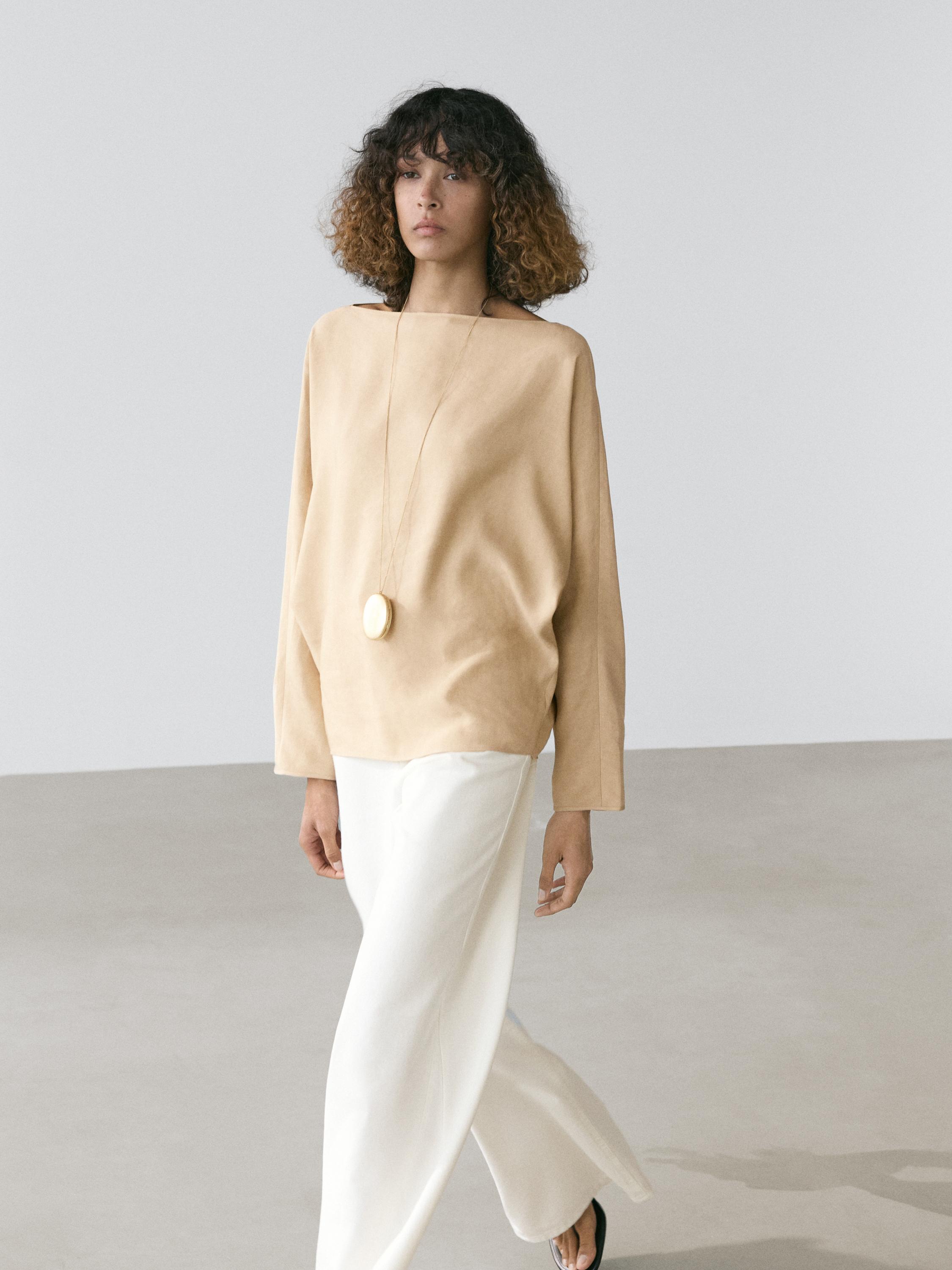 Beige boat neck shirt and wide-leg white pants set.