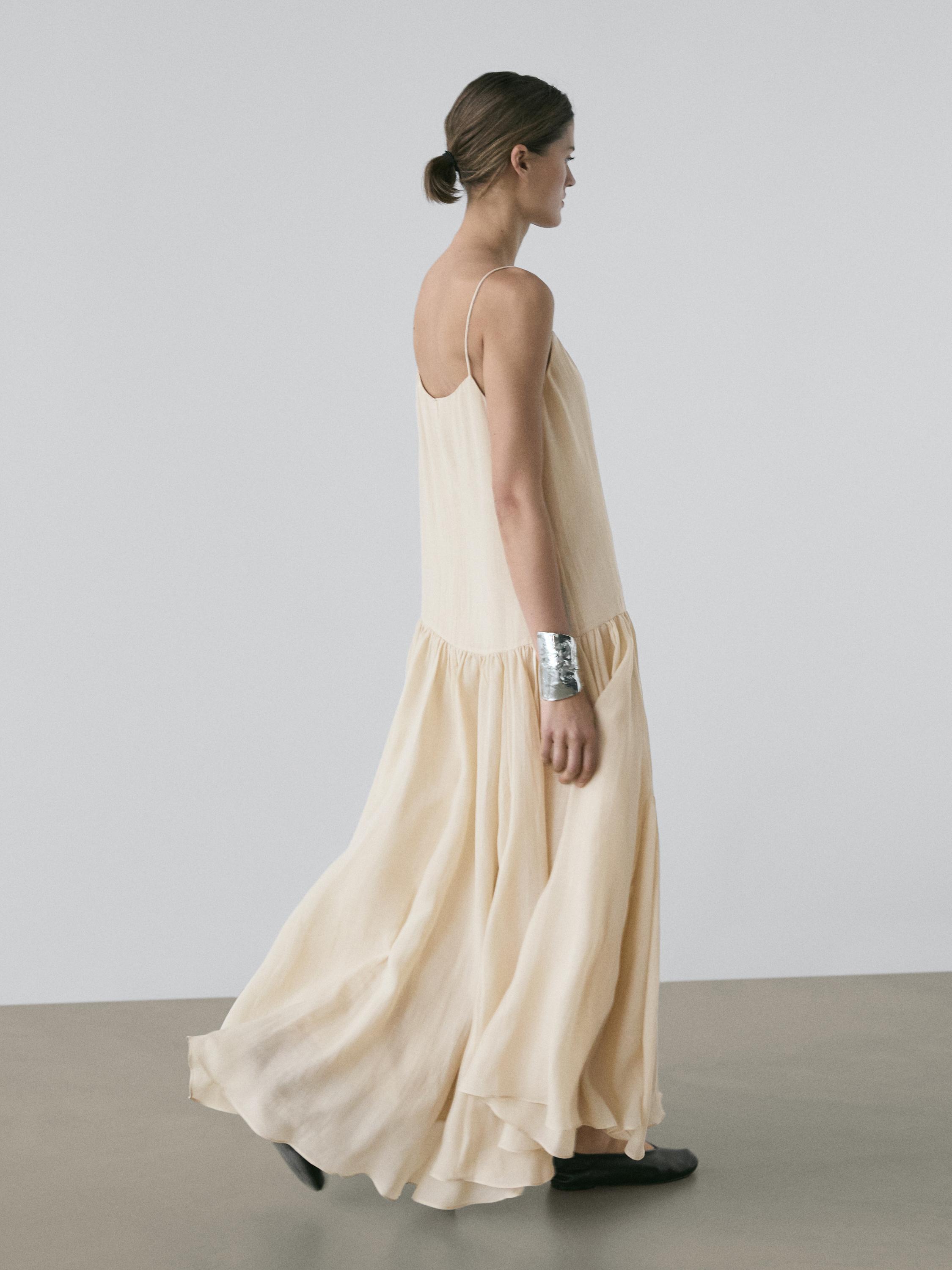 Ensemble de robe midi fluide écrue à fines bretelles et détail plissé sur la jupe.