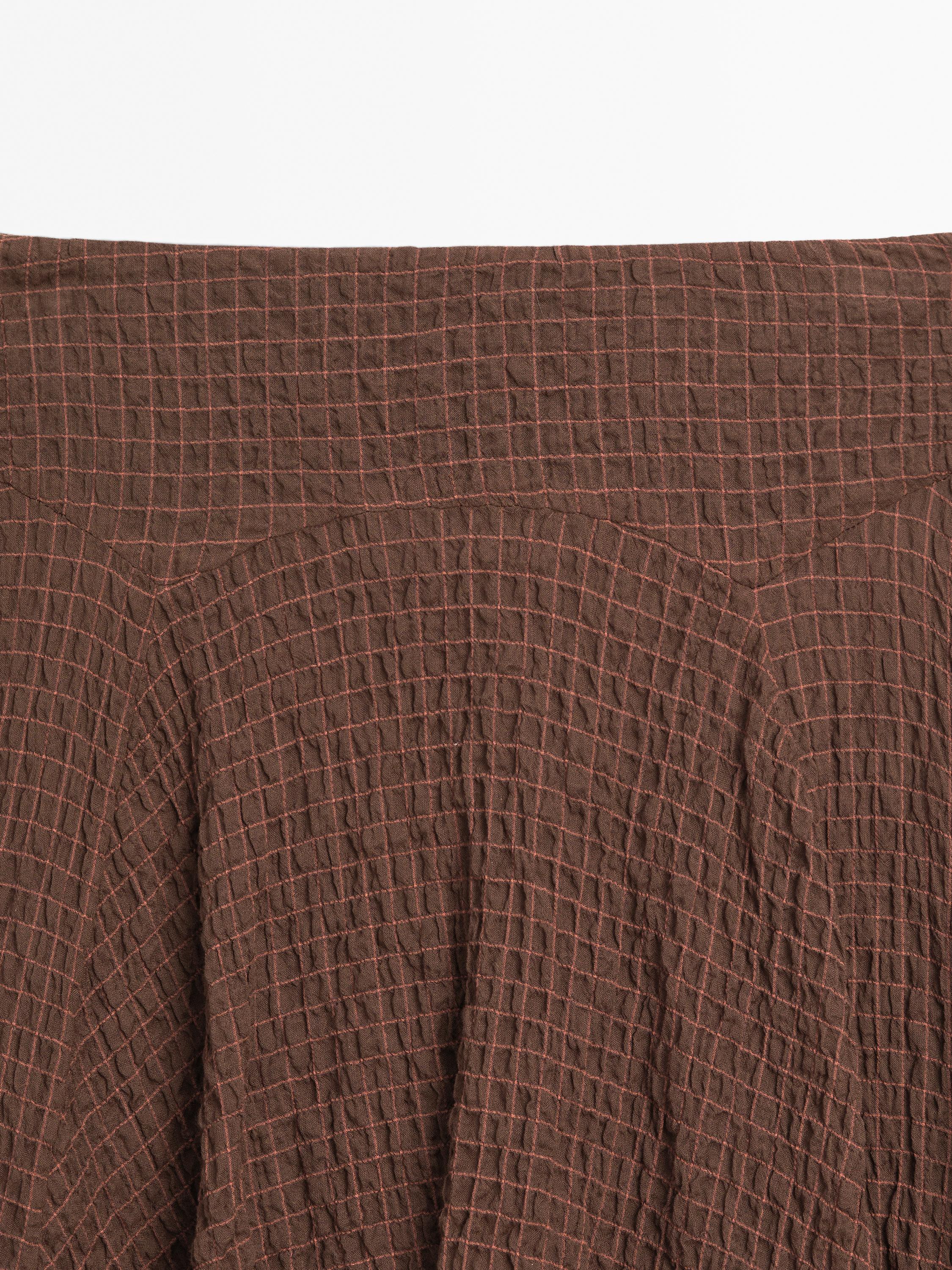 Flowing check skirt with asymmetric hem
