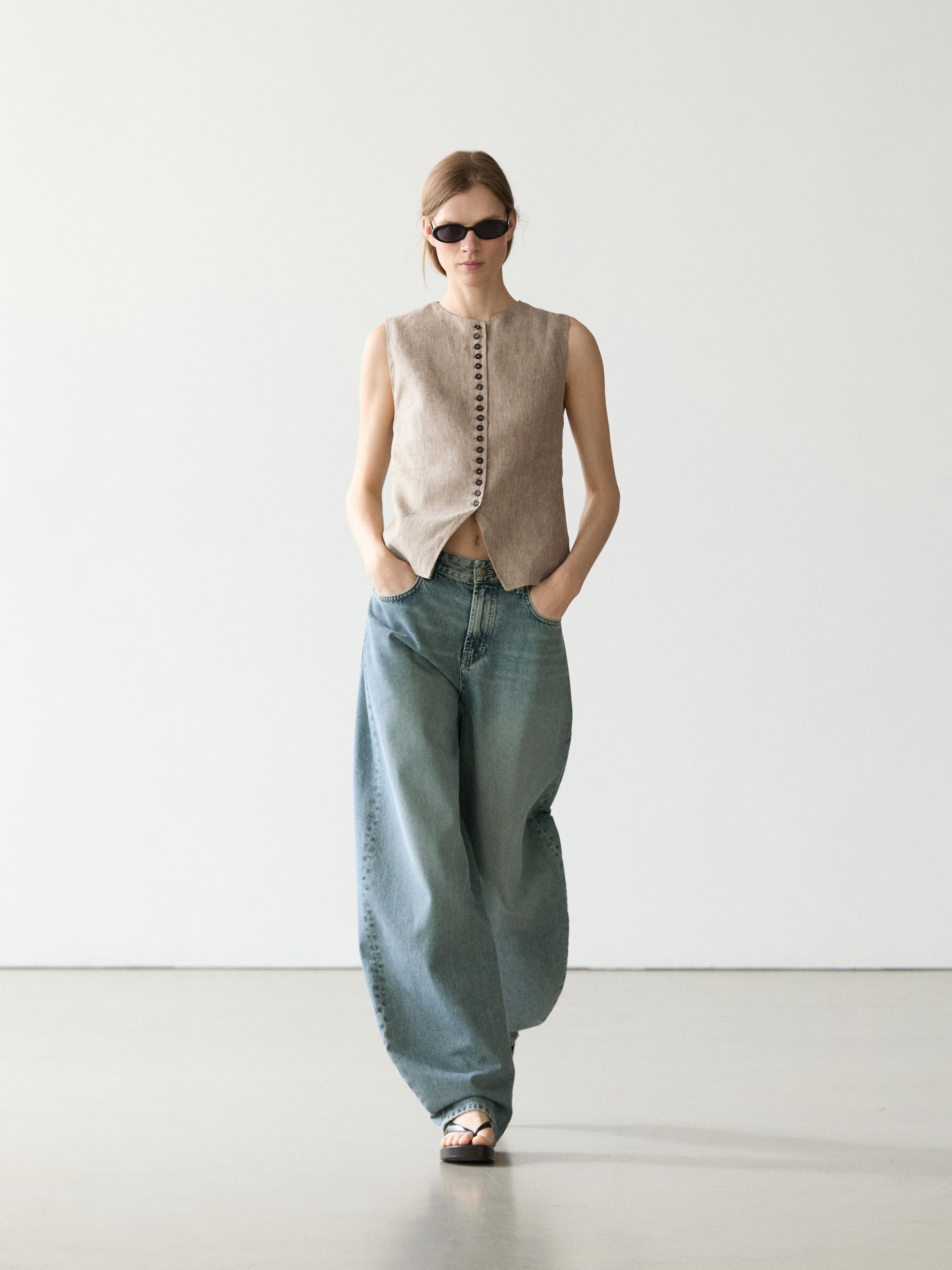 Beiges Westen-Set mit Knopfleiste vorne und weiten Jeans mit Seitentaschen.